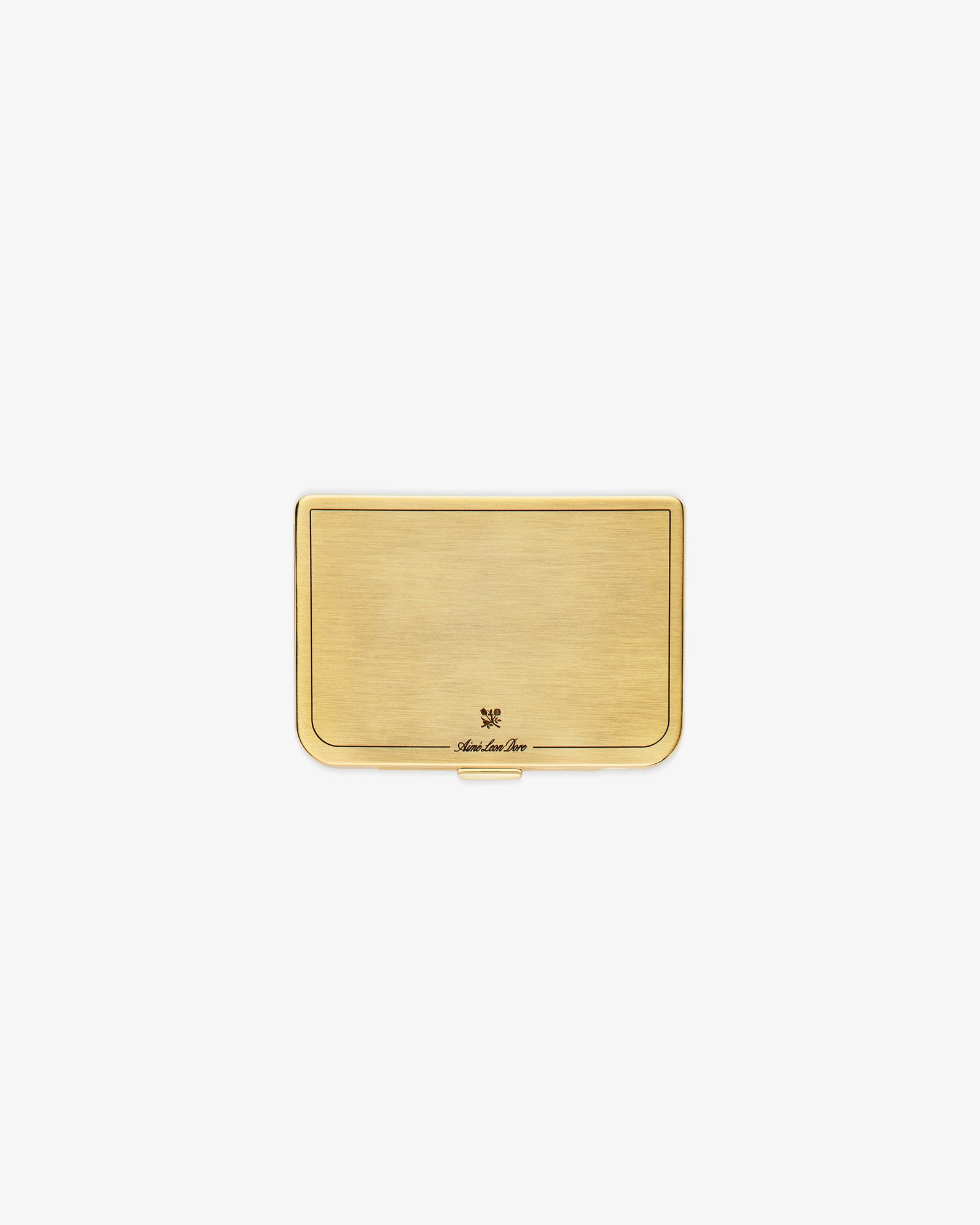 The Brass Card Case is a rectangular gold metal holder with a brushed finish and a small engraved logo at the bottom.