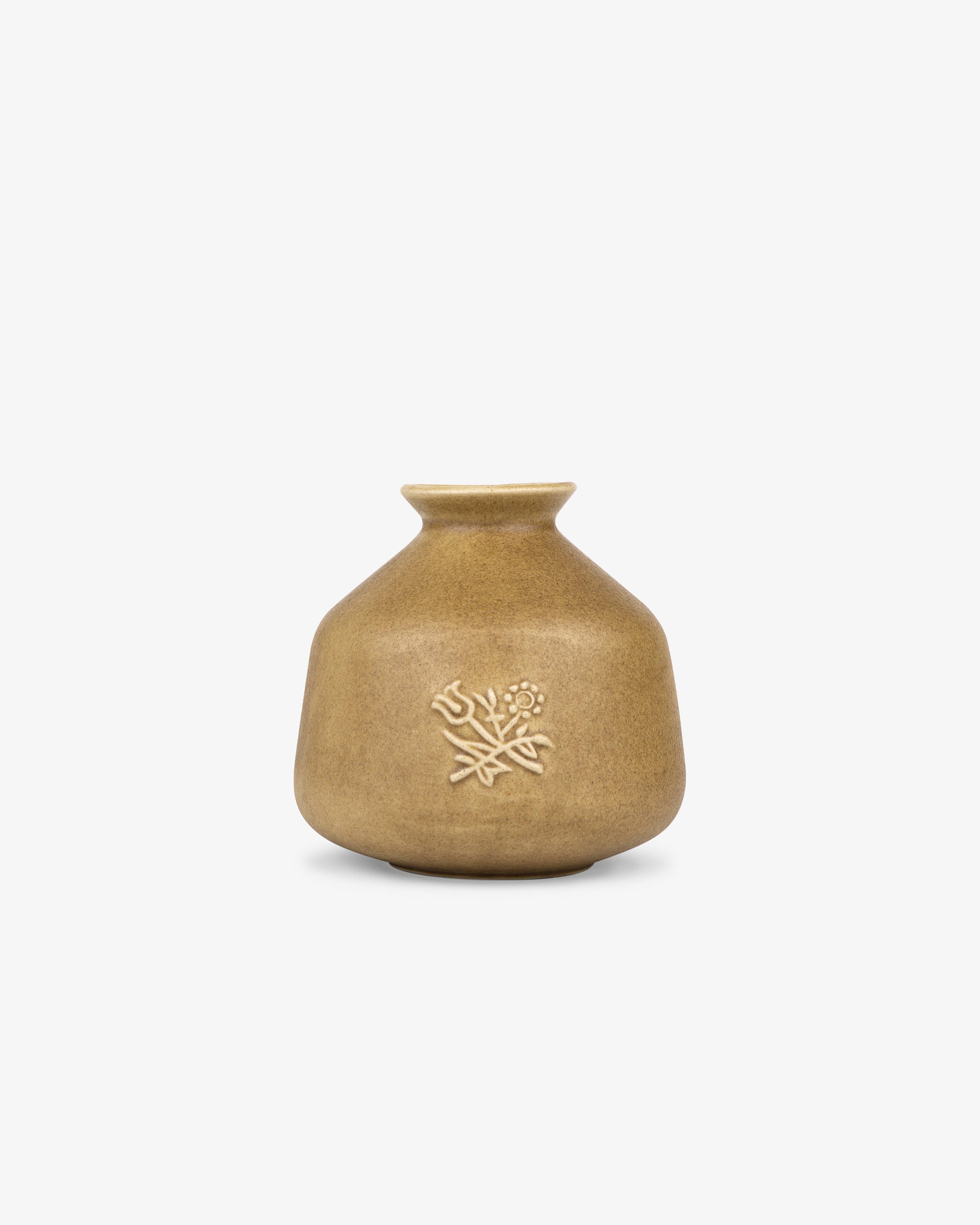 Queens Crest Artisanal Bud Vase—small matte brown ceramic with narrow neck, embossed floral design, on white background.
