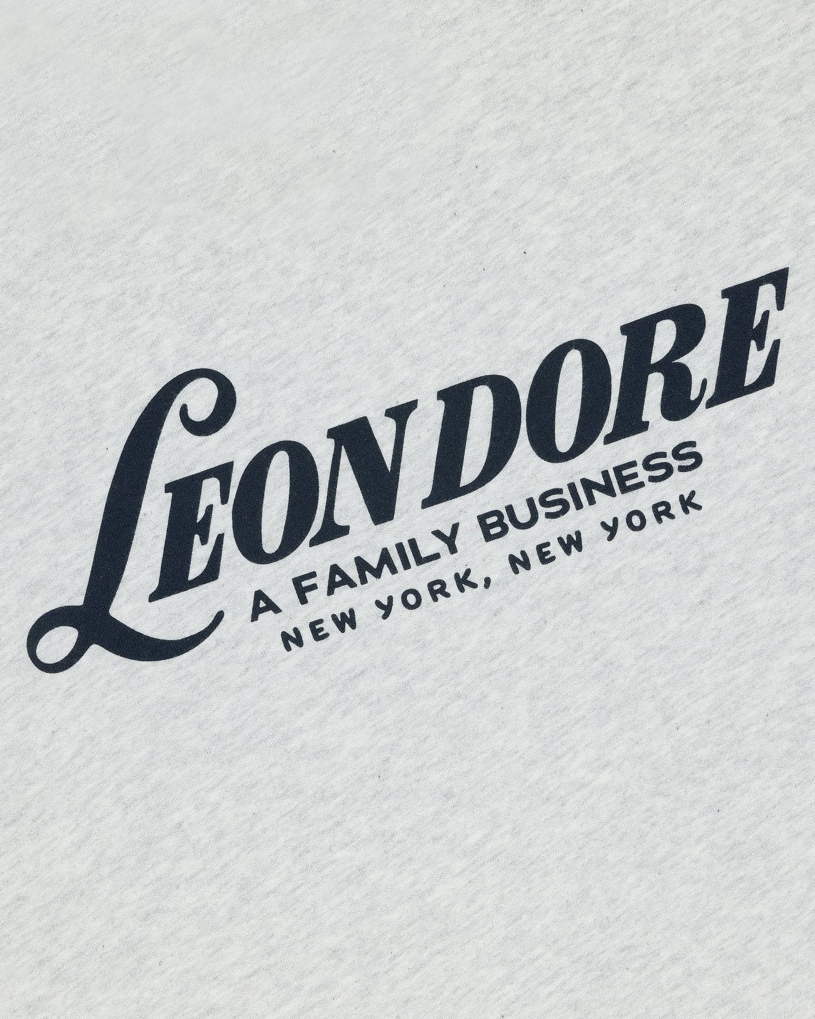 White Leon Dore Tee featuring bold black "A FAMILY BUSINESS NEW YORK, NEW YORK" text on white fabric.