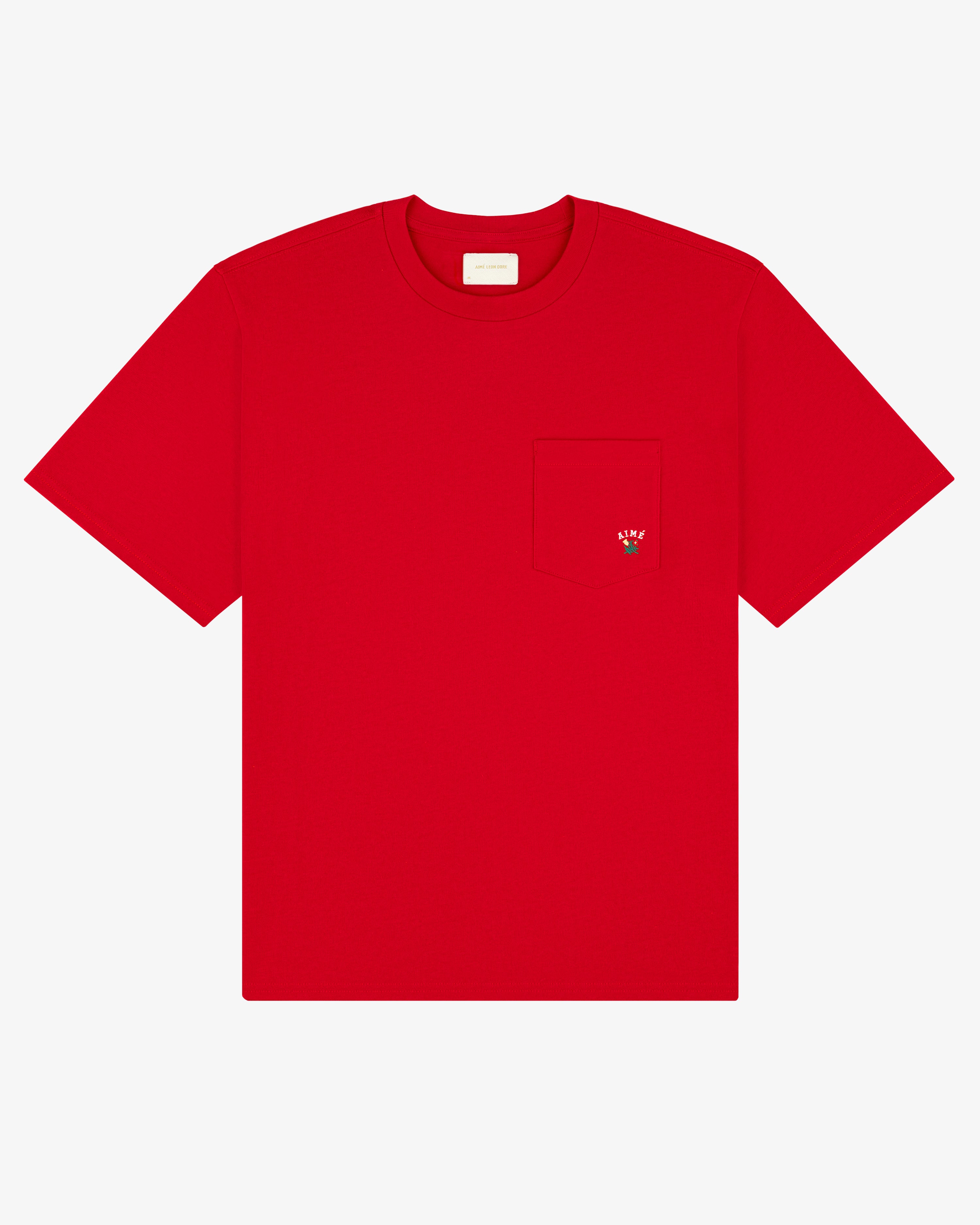 The Crest Pocket Tee is a plain red T-shirt with a chest pocket and a small embroidered strawberry on it.