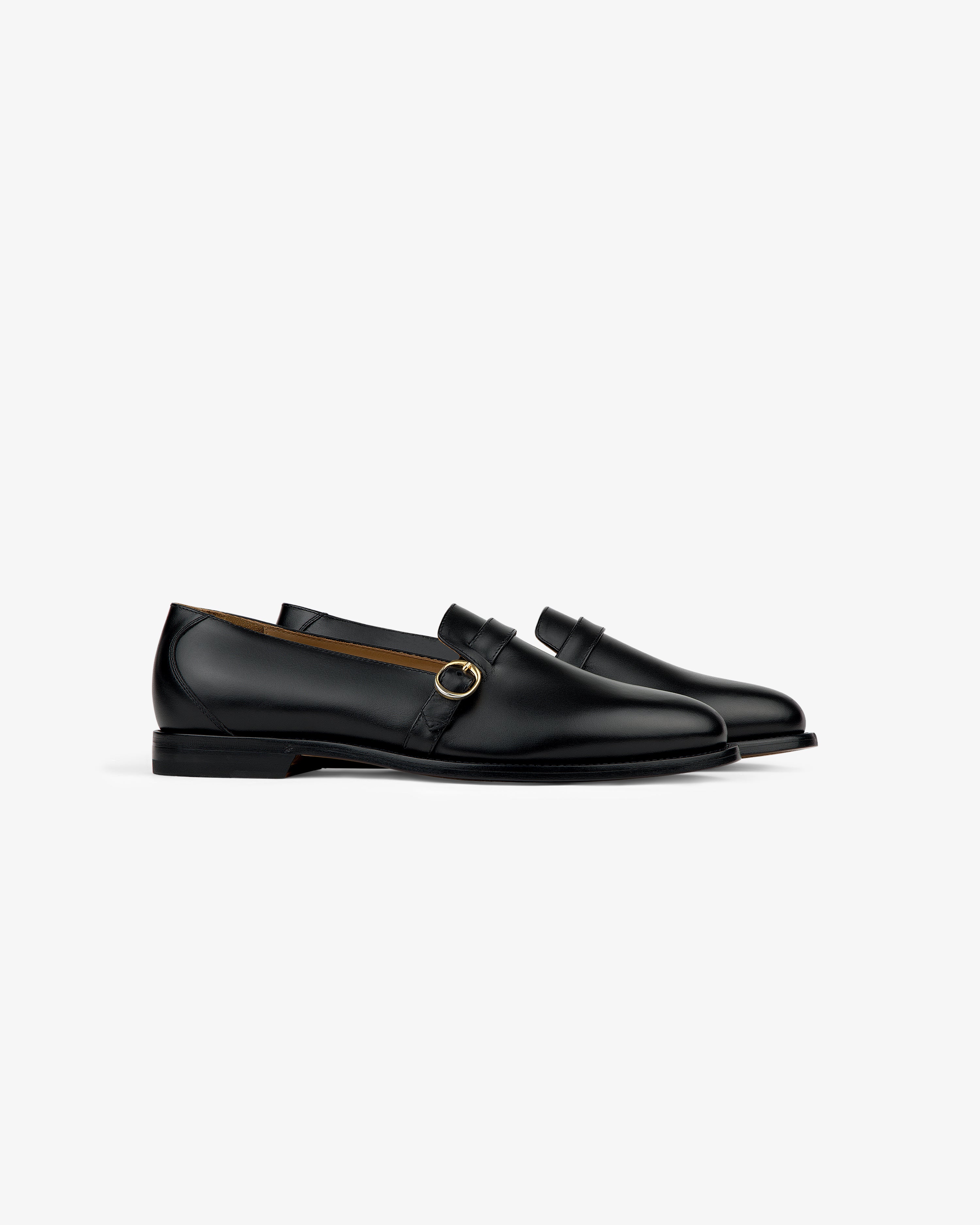 Venetian Buckle Loafer in black leather with a gold buckle, displayed in profile on a white background.