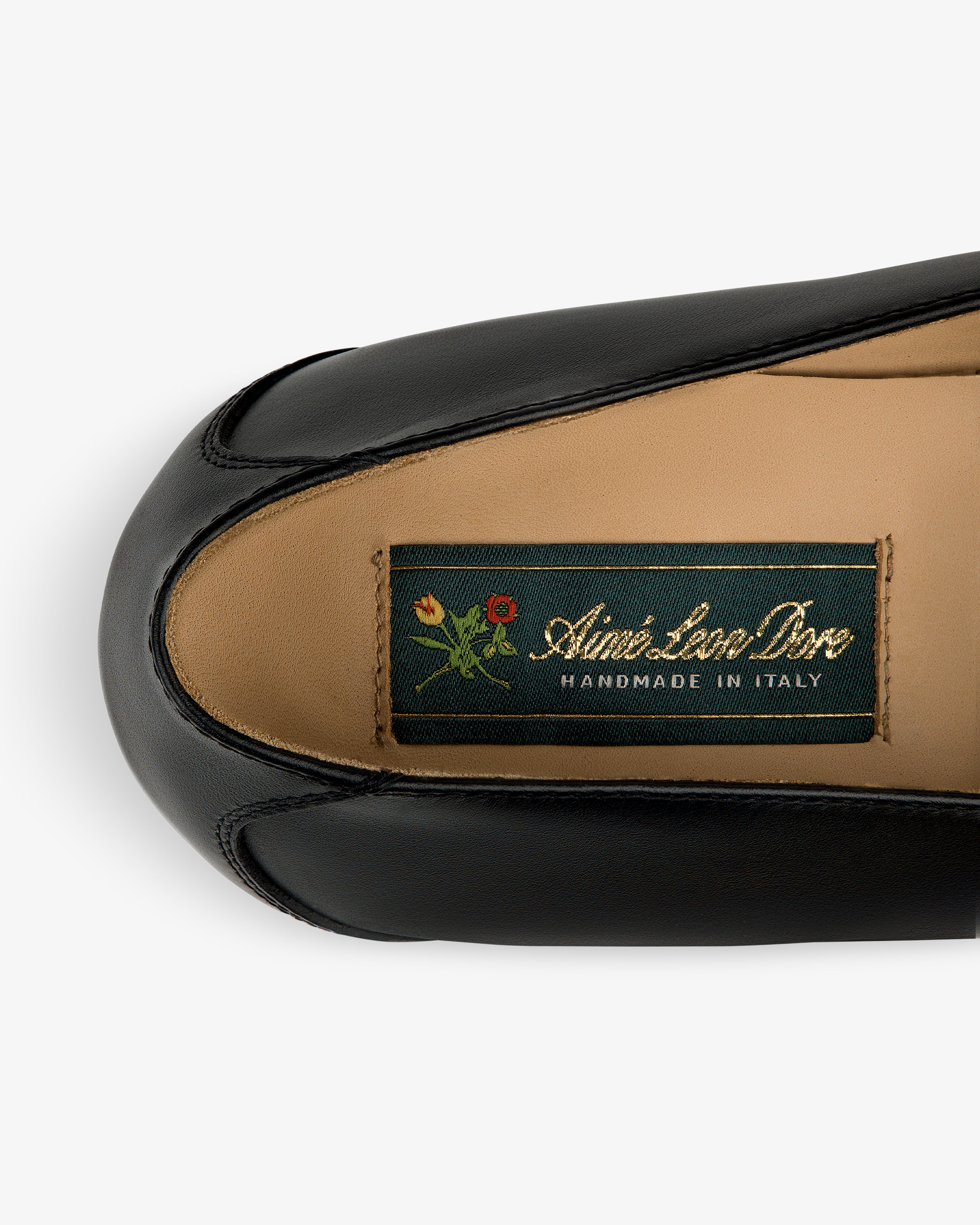 Venetian Buckle Loafer in black leather with “Aimé Leon Dore Handmade in Italy” tag and small flower graphic.