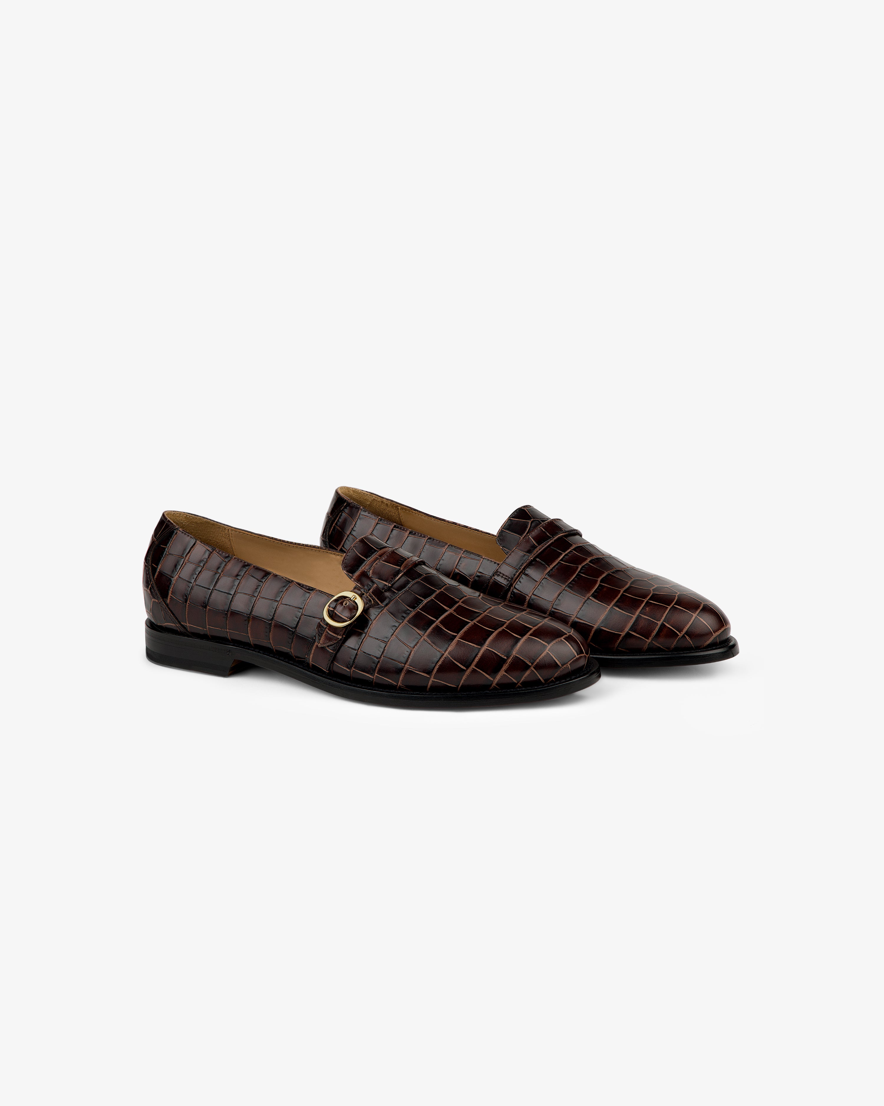 Venetian Croc Buckle Loafer: brown crocodile-pattern loafers with black heels and gold buckle, on white background.