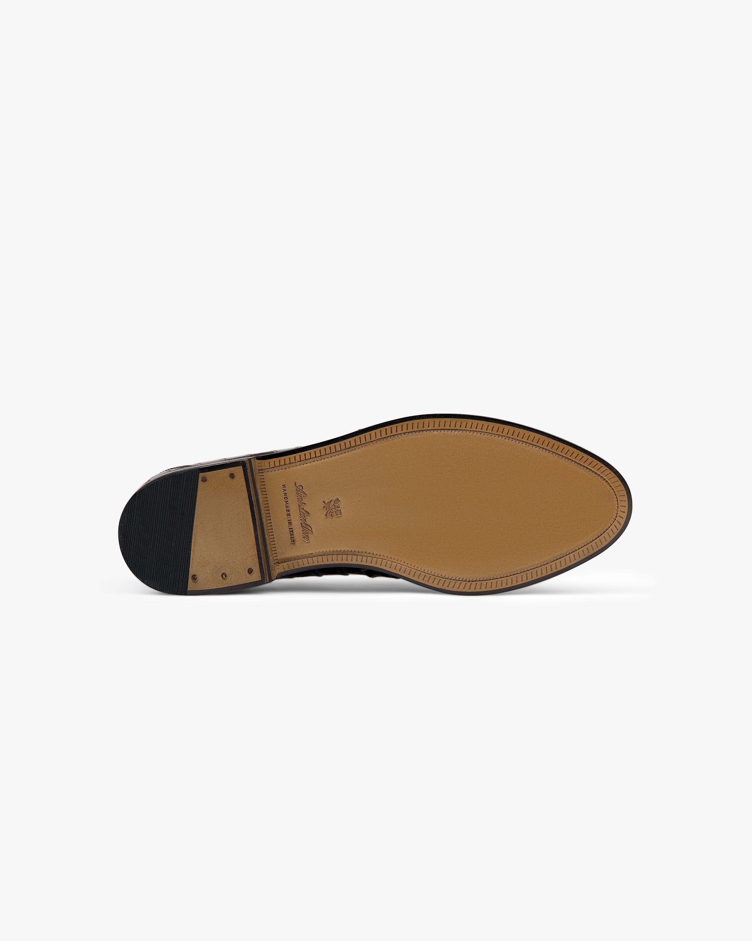 The bottom view of the Venetian Croc Buckle Loafer, featuring a stitched sole and a modest heel.