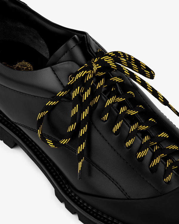 Leather Derby Hiker with black and yellow striped laces, angled top view on a white background.