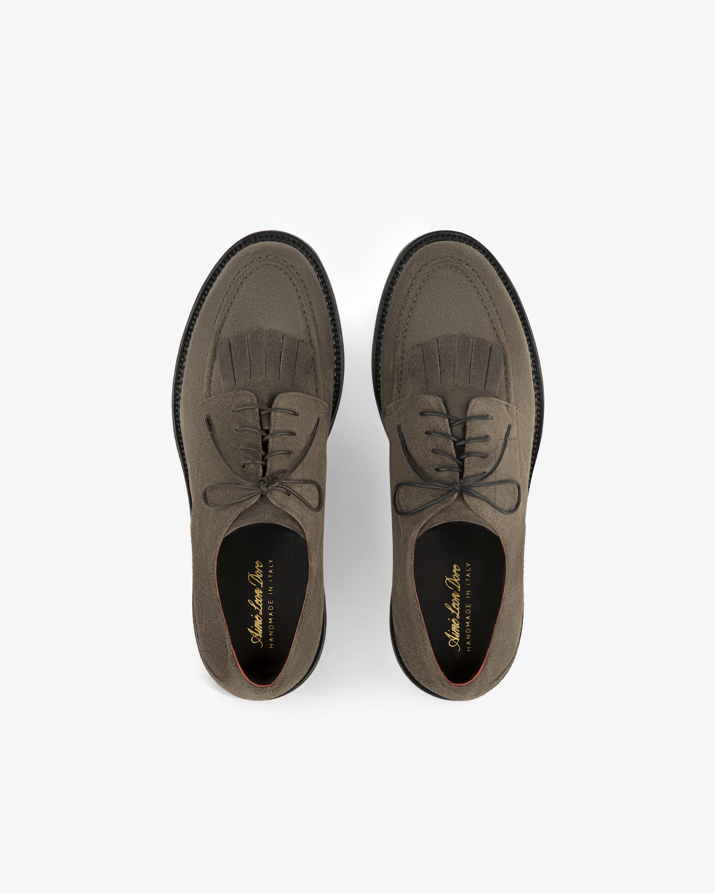 Suede Lug Sole Derby: brown suede lace-up shoes with brogue detailing and fringe on a white background.