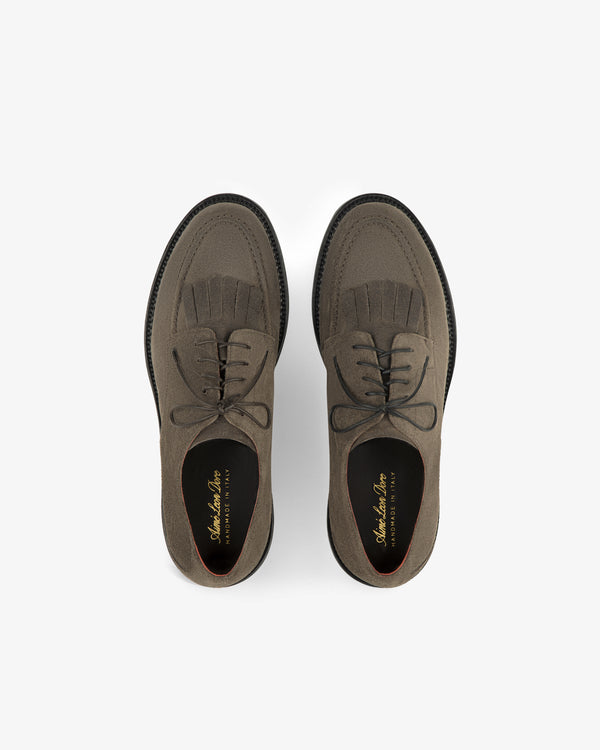 Suede Lug Sole Derby: brown suede lace-up shoes with brogue detailing and fringe on a white background.