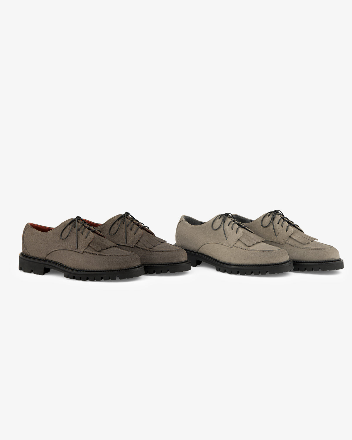 Two Suede Lug Sole Derby pairs in brown and taupe, both with black rubber soles, on a white background.