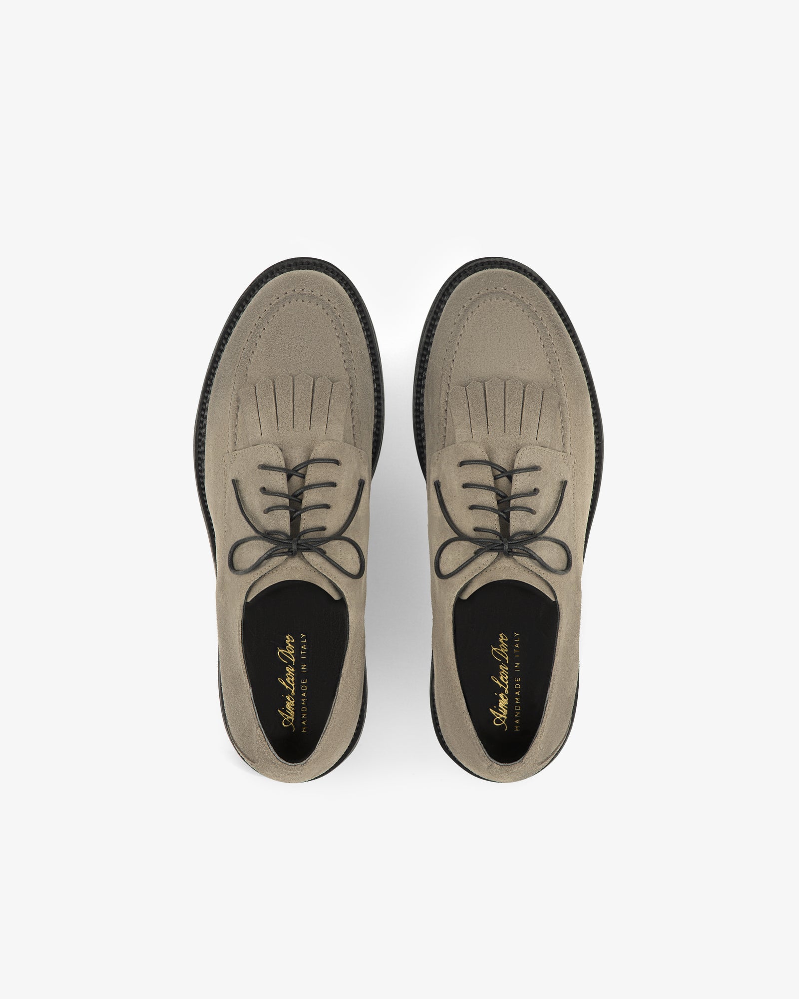 Top view of Suede Lug Sole Derby shoes in light brown, with black laces and soles, on a white background.