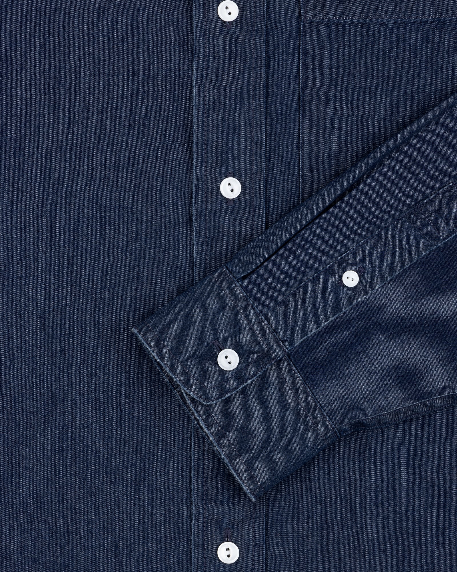 Close-up of the Denim Collarband Shirt in dark blue with white buttons, chest pocket, and sleeve visible.