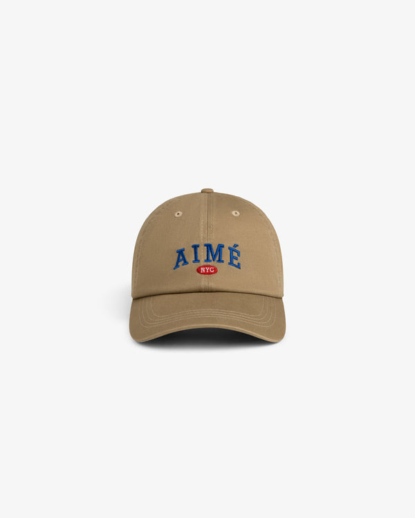 Aimé Souvenir Hat: Beige cap with blue AIMÉ and a red NYC patch on the front.
