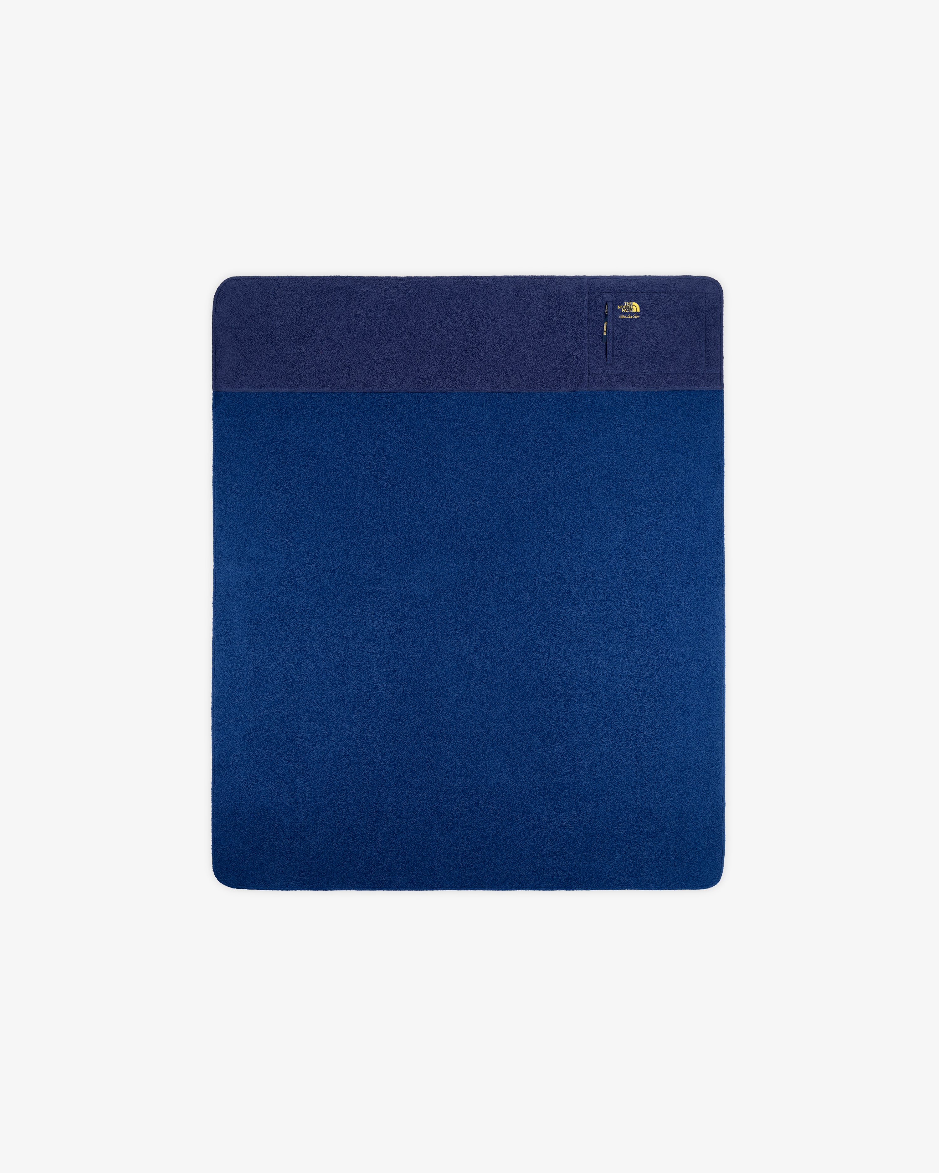 ALD / The North Face Packable Fleece Blanket: square blue throw with dark section, zip pocket; shown on white.