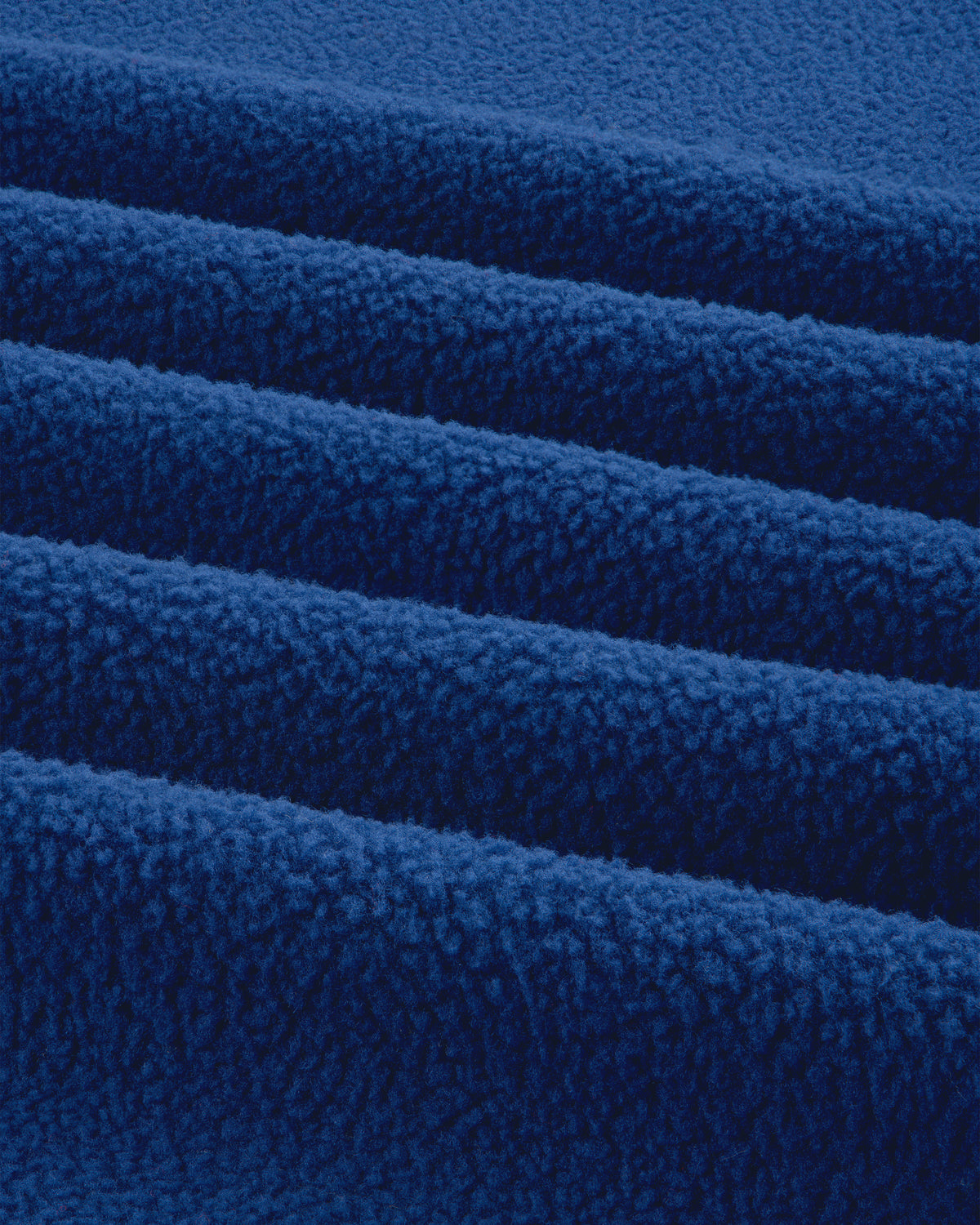 Close-up of the ALD / The North Face Packable Fleece Blanket, showing its soft, bright blue textured layers.