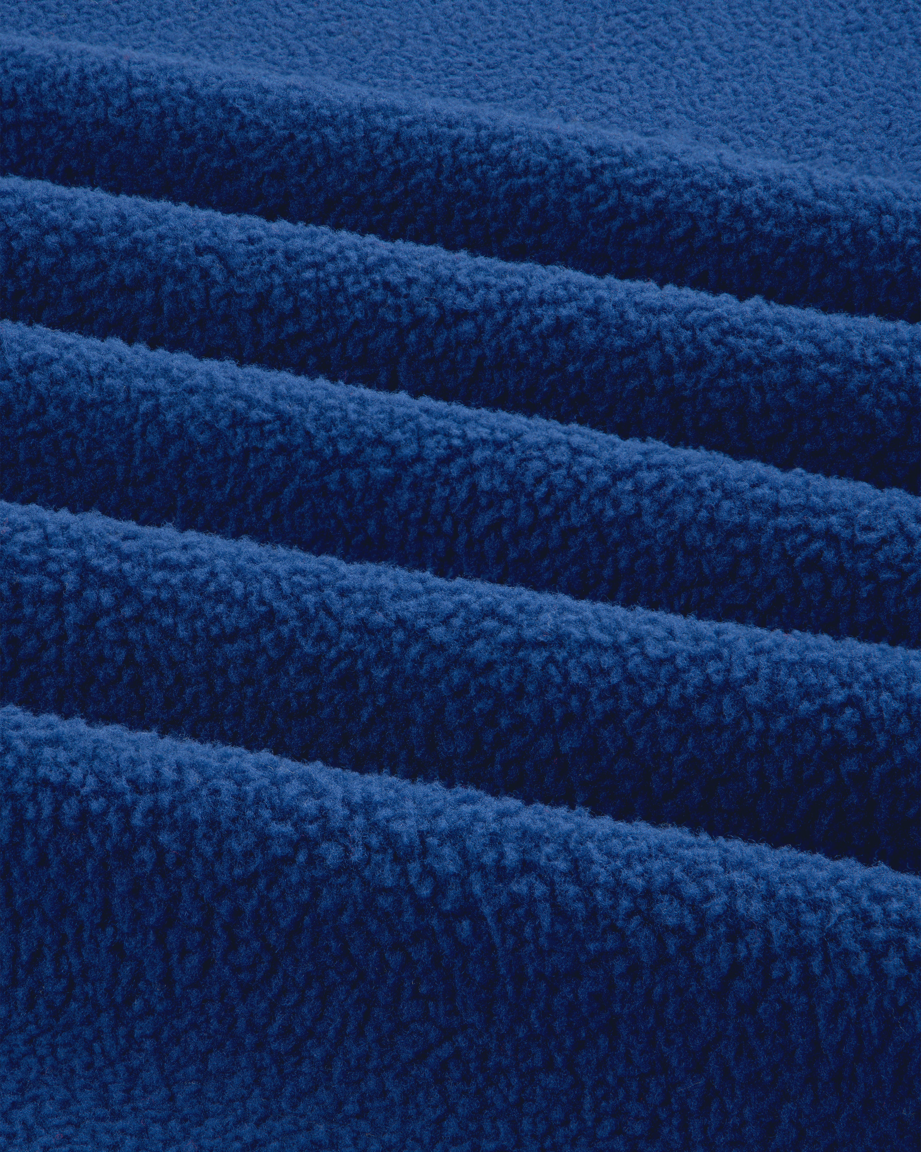 Close-up of the ALD / The North Face Packable Fleece Blanket, showing its soft, bright blue textured layers.
