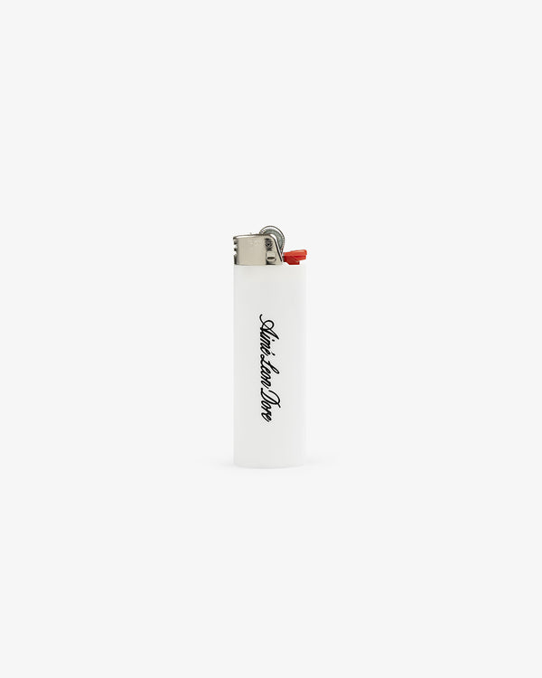 White Caricature Lighter with metal top and “Saturdays New York City” in black vertical script.