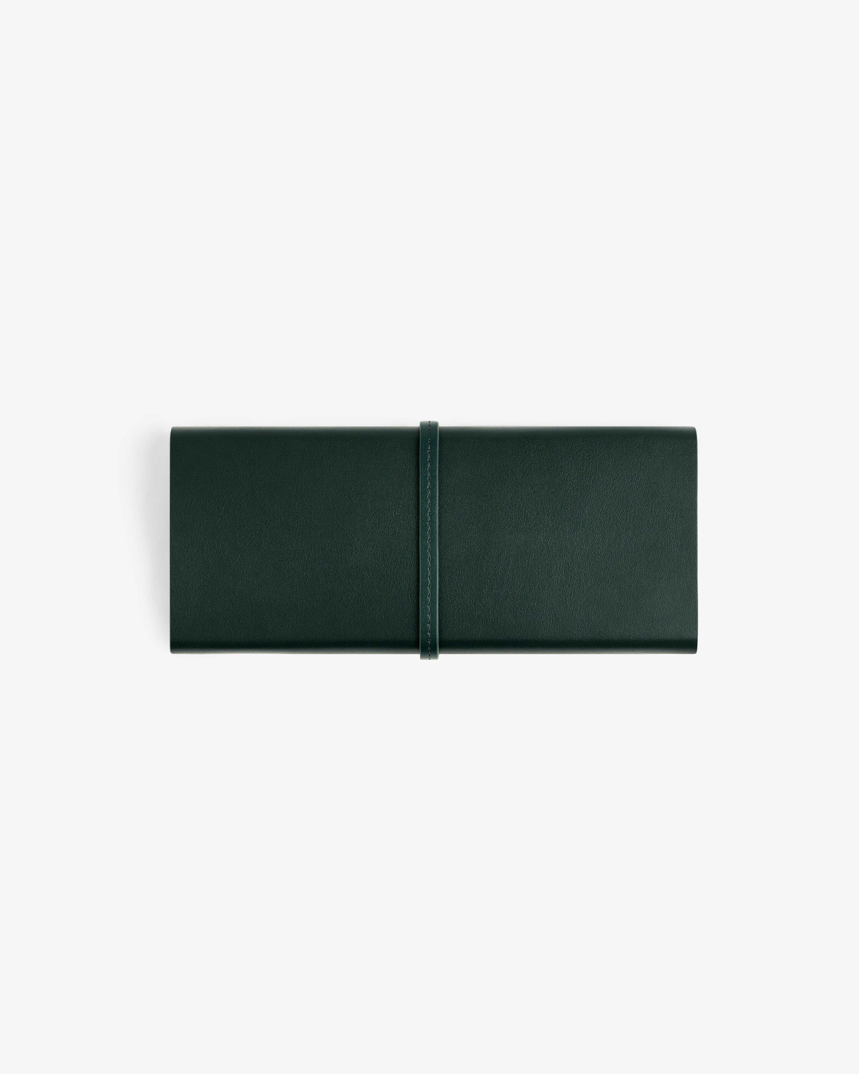 A closed Brass Measurement Kit with a wrap-around strap in dark green leather, on a white background.