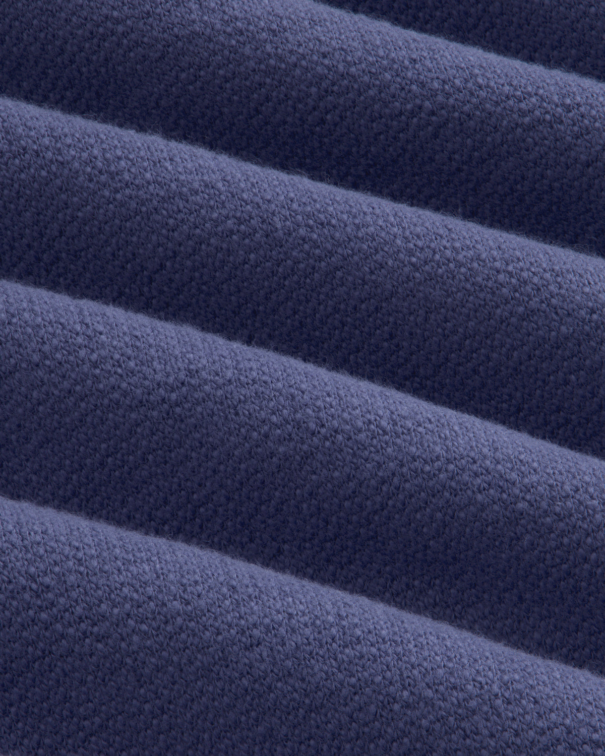 Close-up of Stone Washed Marina Sweatpants: folded dark blue fabric with textured weave and soft, raised ridges.
