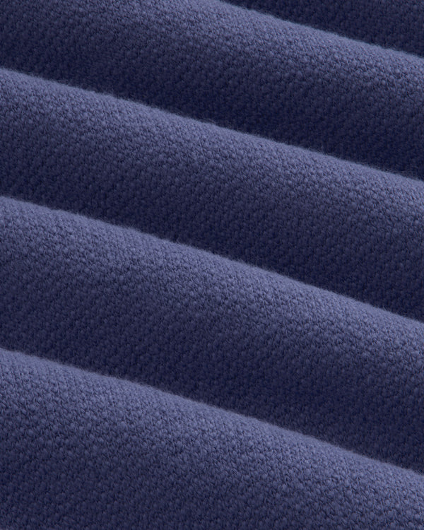 Close-up of Stone Washed Marina Sweatpants: folded dark blue fabric with textured weave and soft, raised ridges.