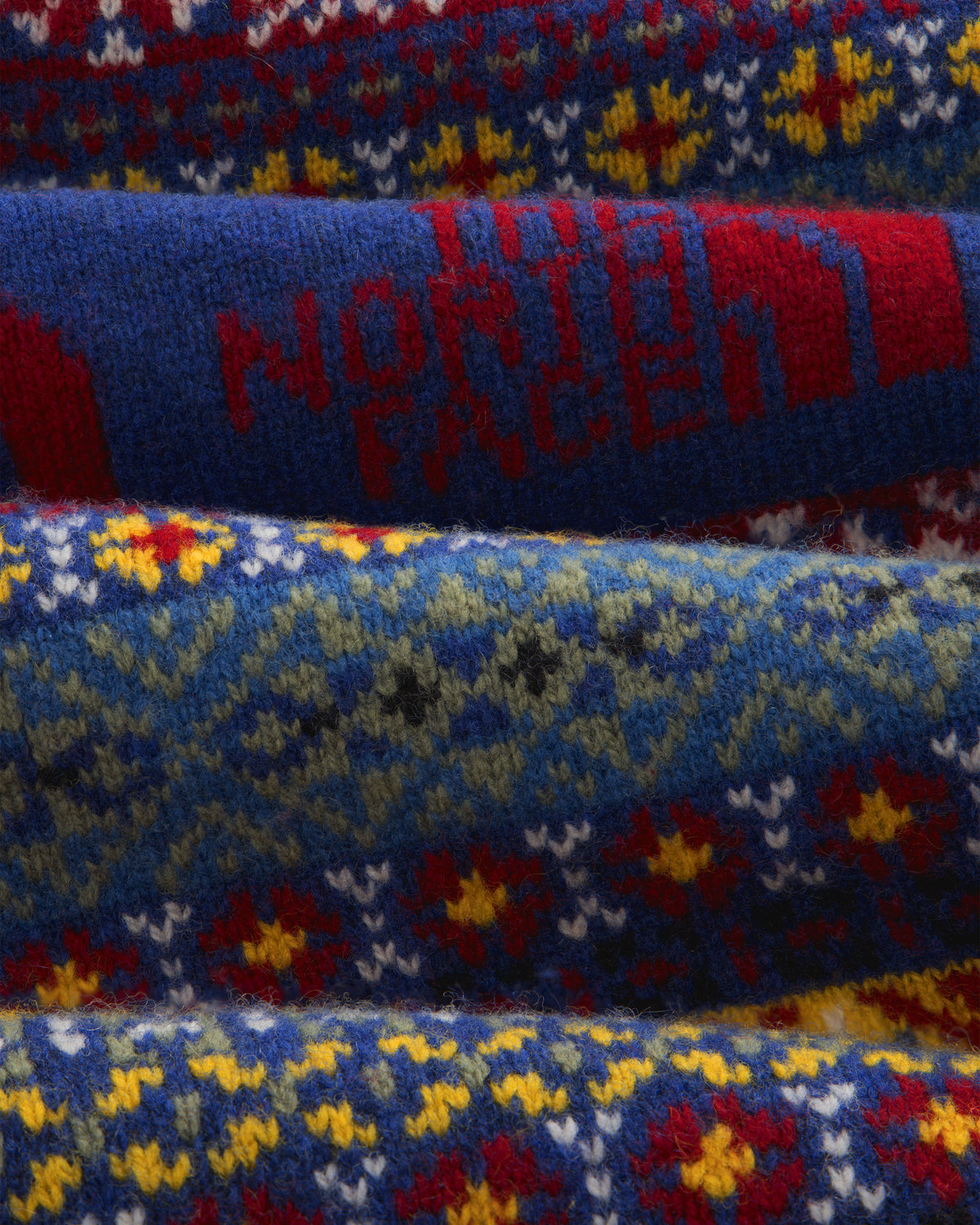 Fair Isle knit polo with colorful pattern, red North Face text, and blue background—ALD/The North Face.