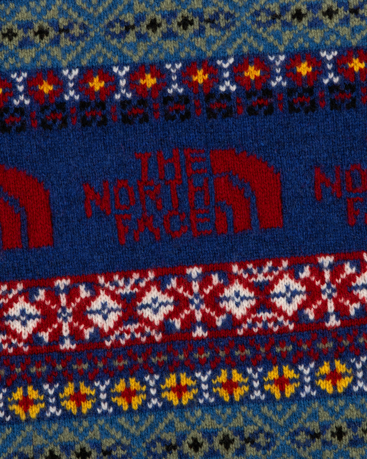 Close-up of the ALD / The North Face Fair Isle Knit Polo with colorful geometric patterns and logo detailing.
