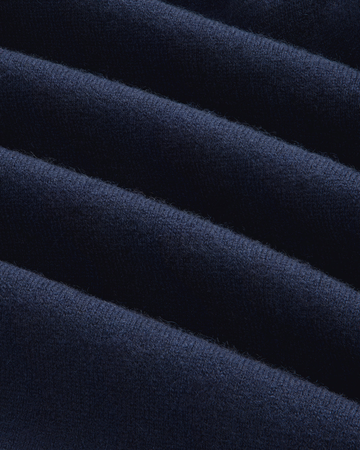 Close-up of the Full-Zip Pavilion Cashmere Hoodie’s dark blue, ribbed fabric with soft, even horizontal ridges.