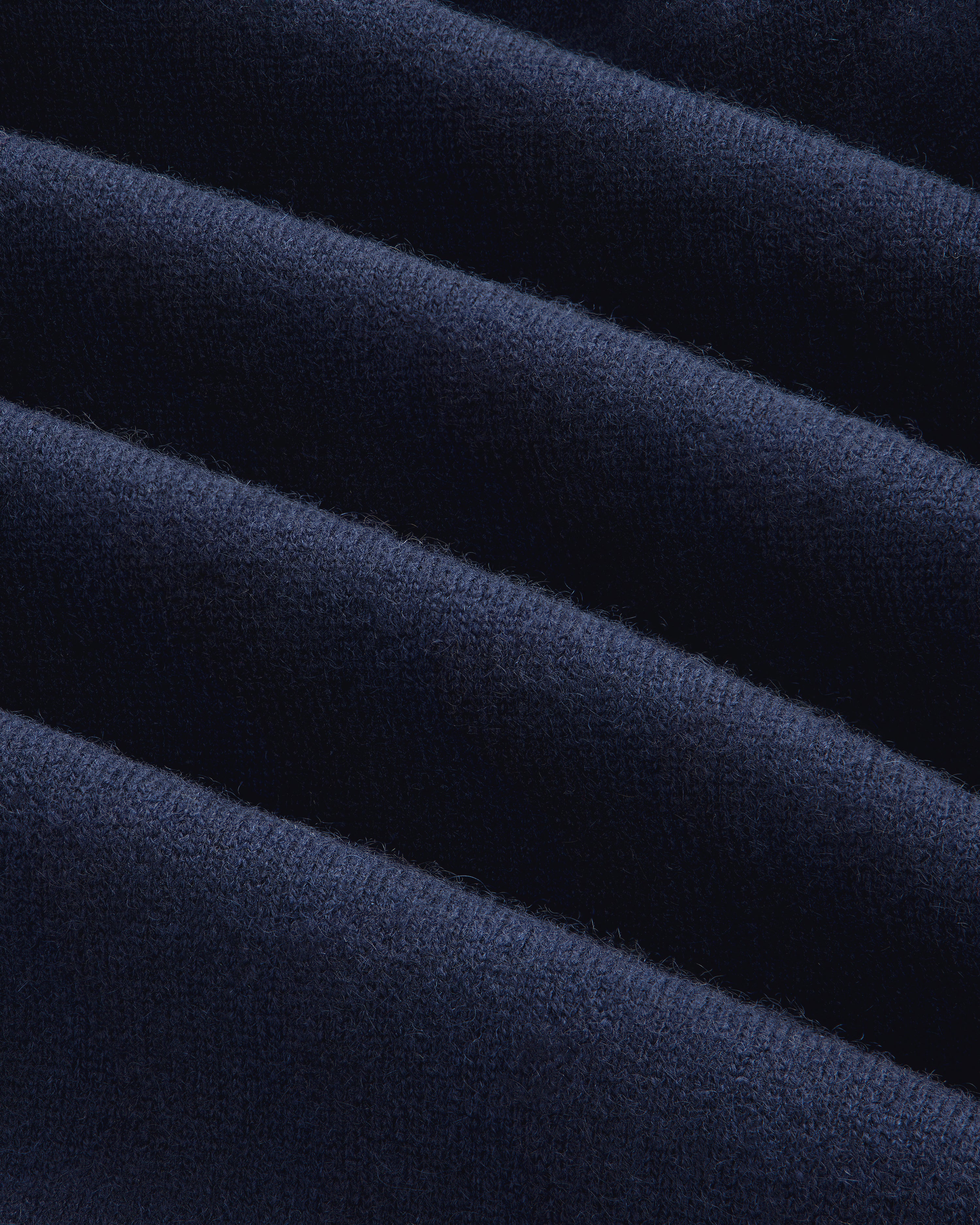 Close-up of the Full-Zip Pavilion Cashmere Hoodie’s dark blue, ribbed fabric with soft, even horizontal ridges.