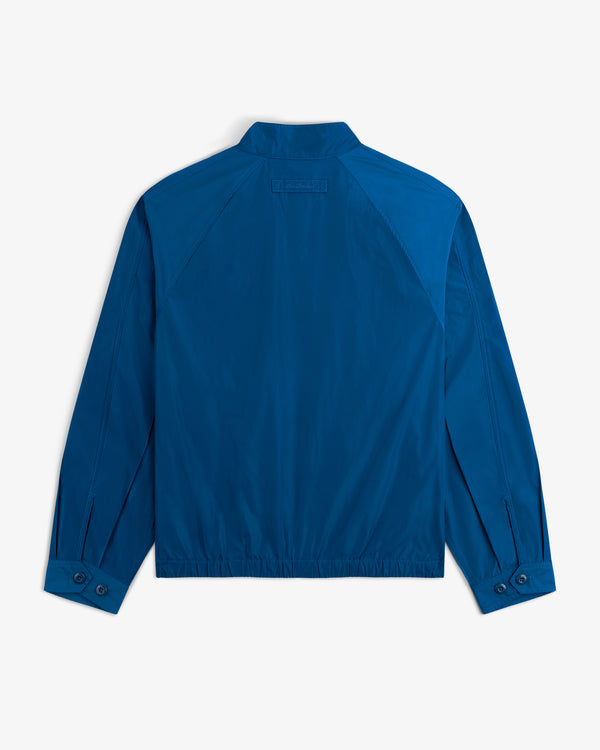The Crest Nylon Windbreaker, shown from the back in blue, features a collar and buttoned cuffs.