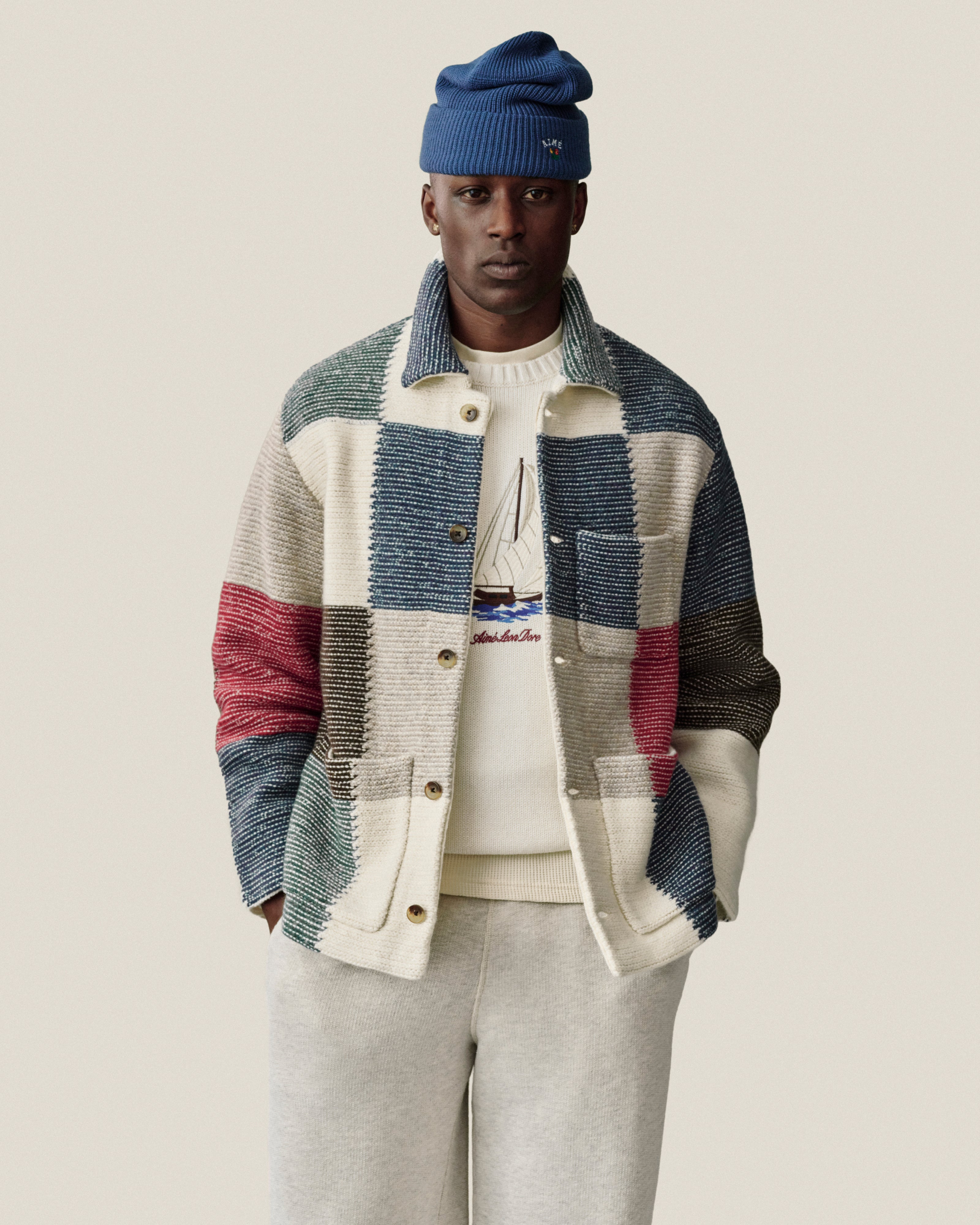 Man in a Regatta Embroidered Crewneck Sweater stands with hands in pockets against a neutral background.