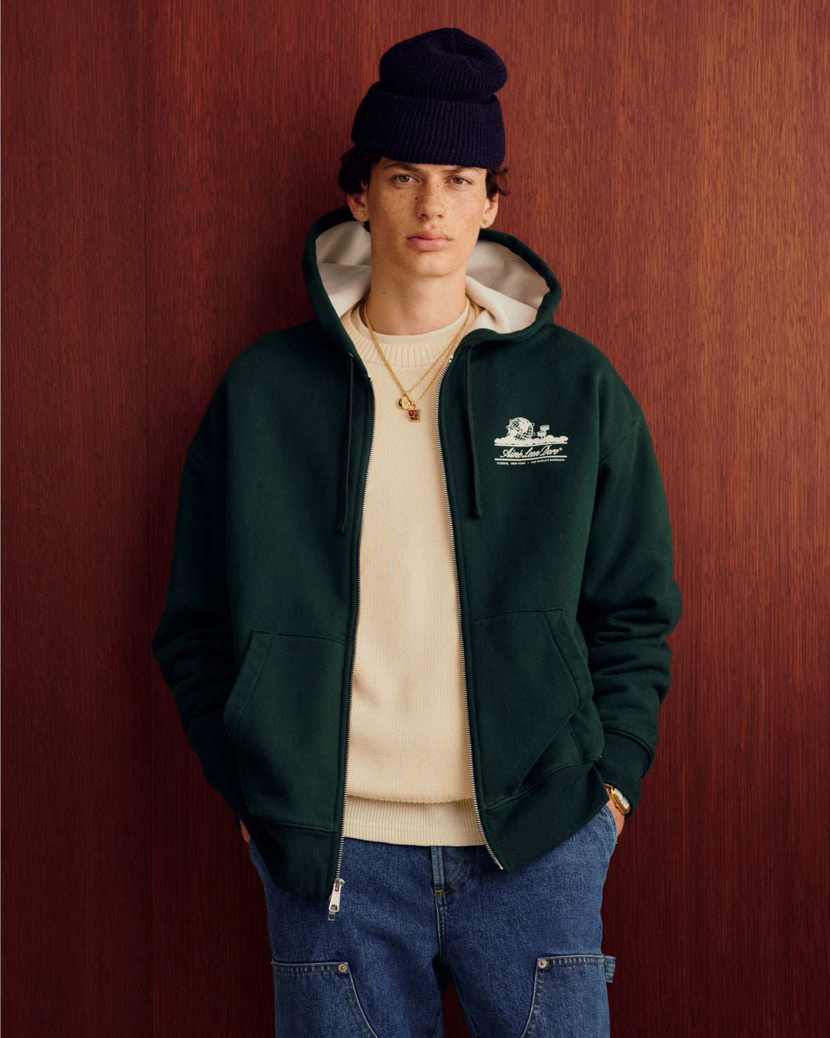 Someone wearing the Unisphere Waffle Lined Full-Zip Hoodie stands in front of a wood wall.