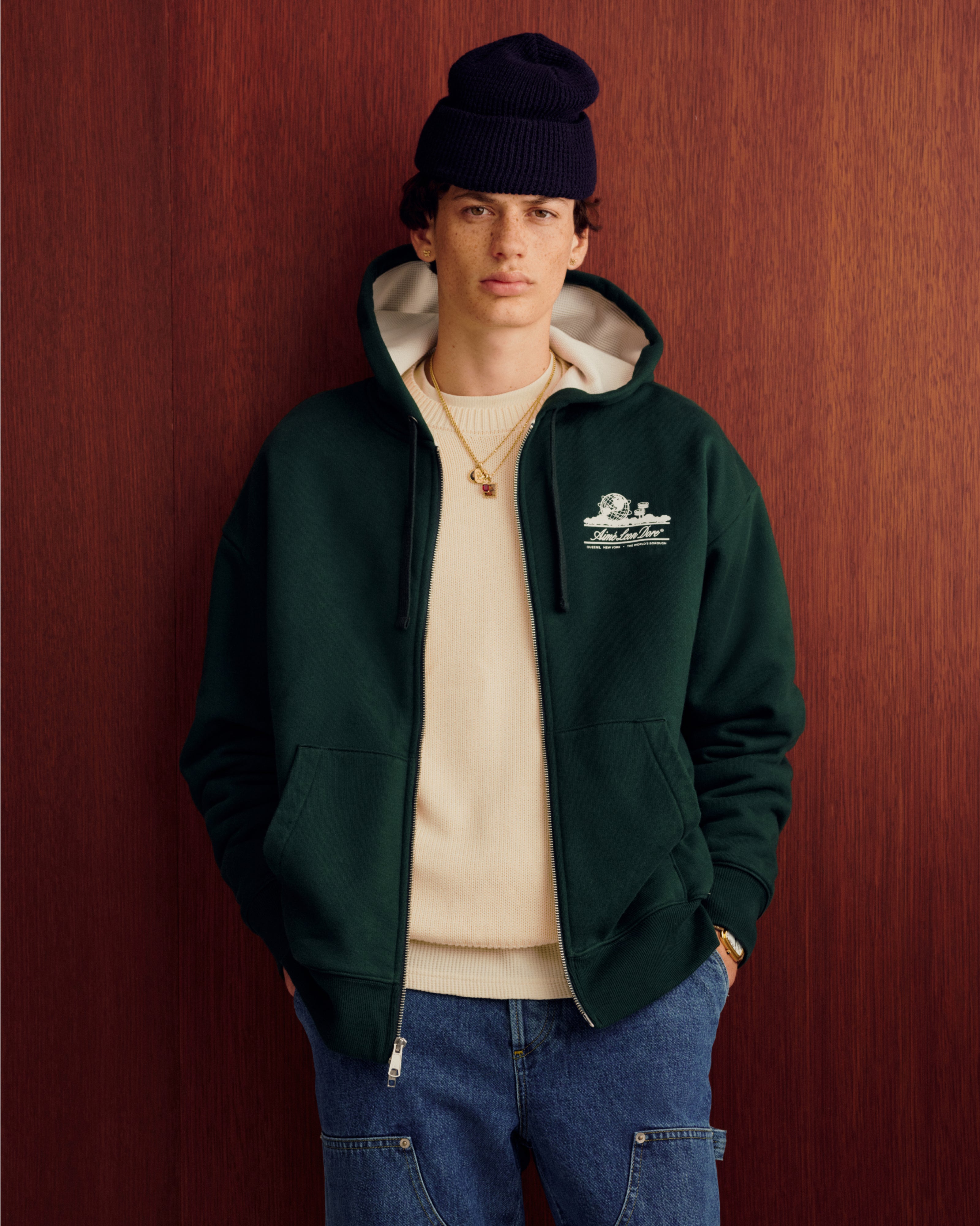 Someone wearing the Unisphere Waffle Lined Full-Zip Hoodie stands in front of a wood wall.