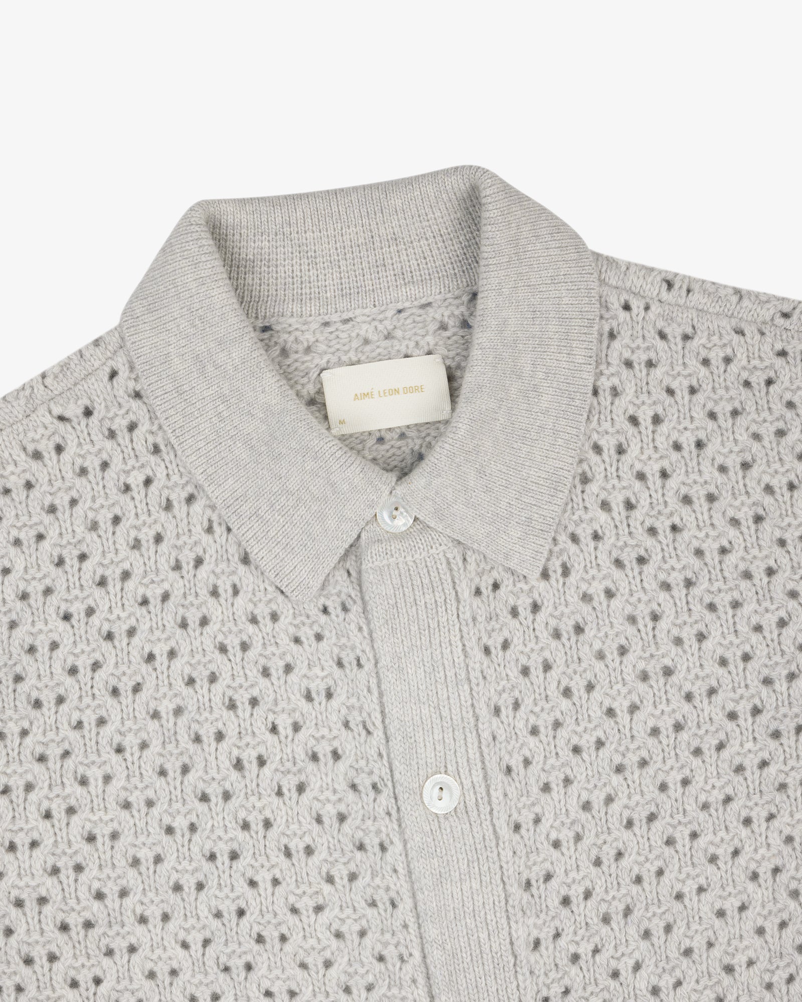 Light gray Knit Polo Cardigan with textured pattern, ribbed placket, and two white buttons, top view.