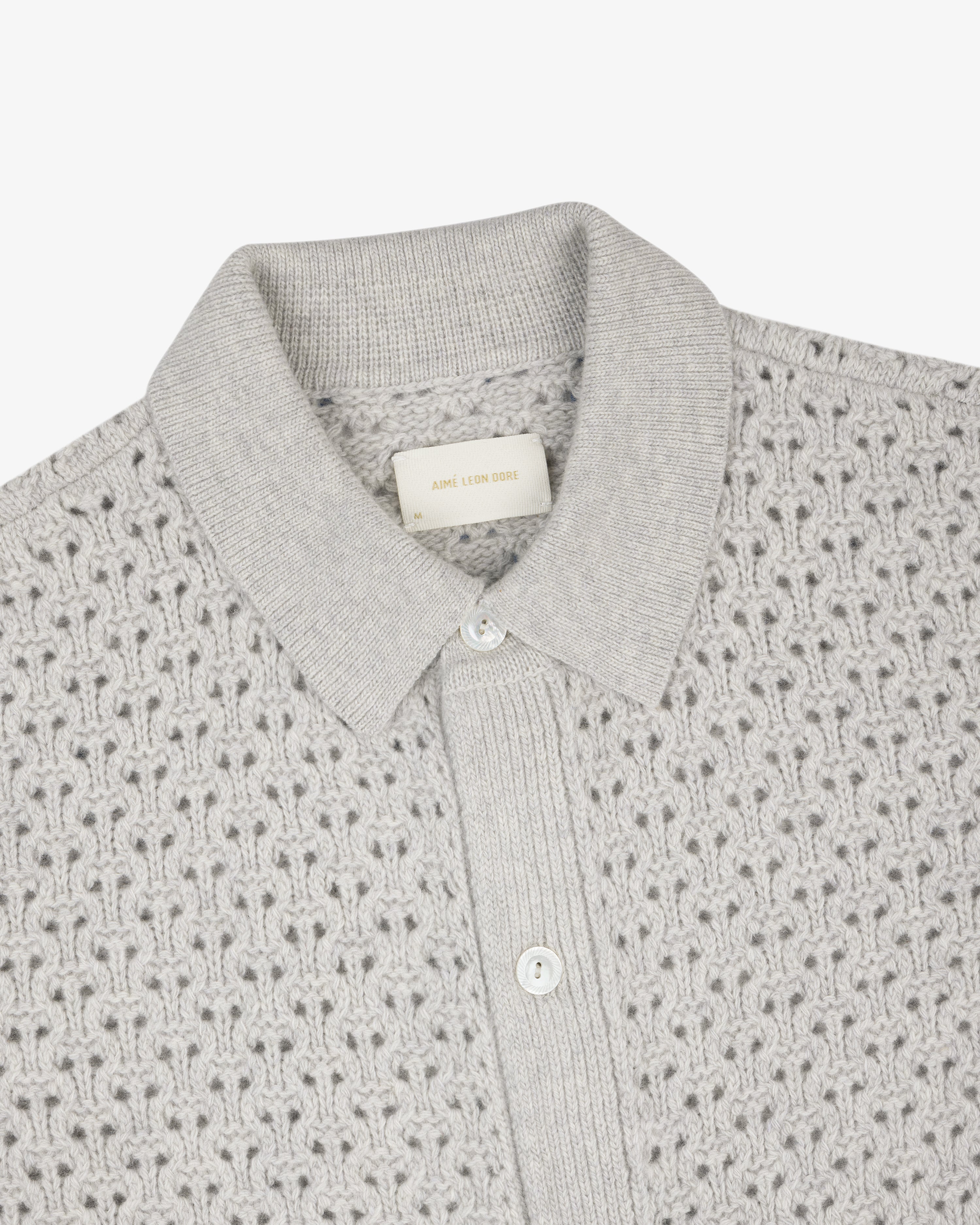Light gray Knit Polo Cardigan with textured pattern, ribbed placket, and two white buttons, top view.