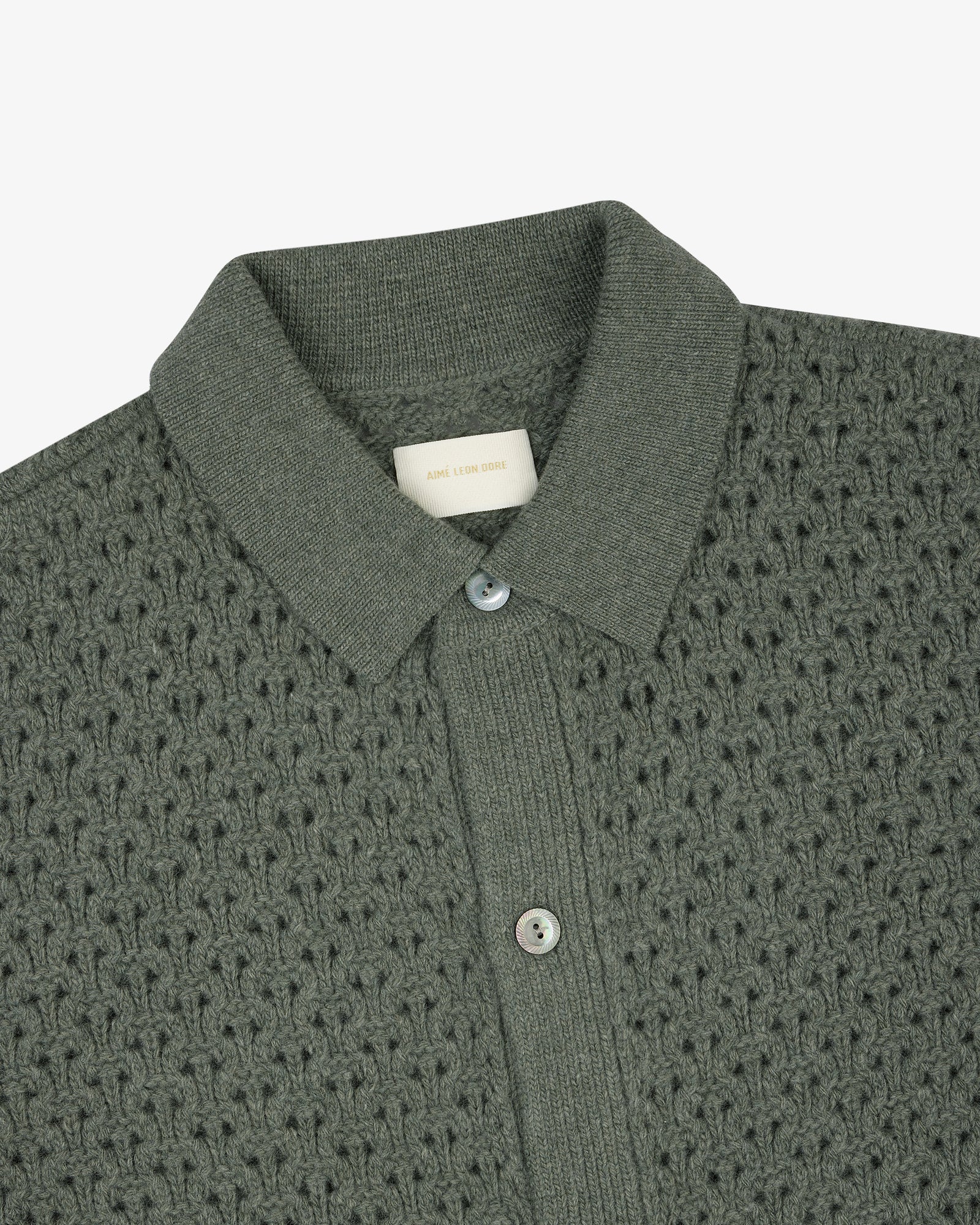 Textured green knit polo cardigan with buttons and an Aime Leon Dore tag at the inside neckline.