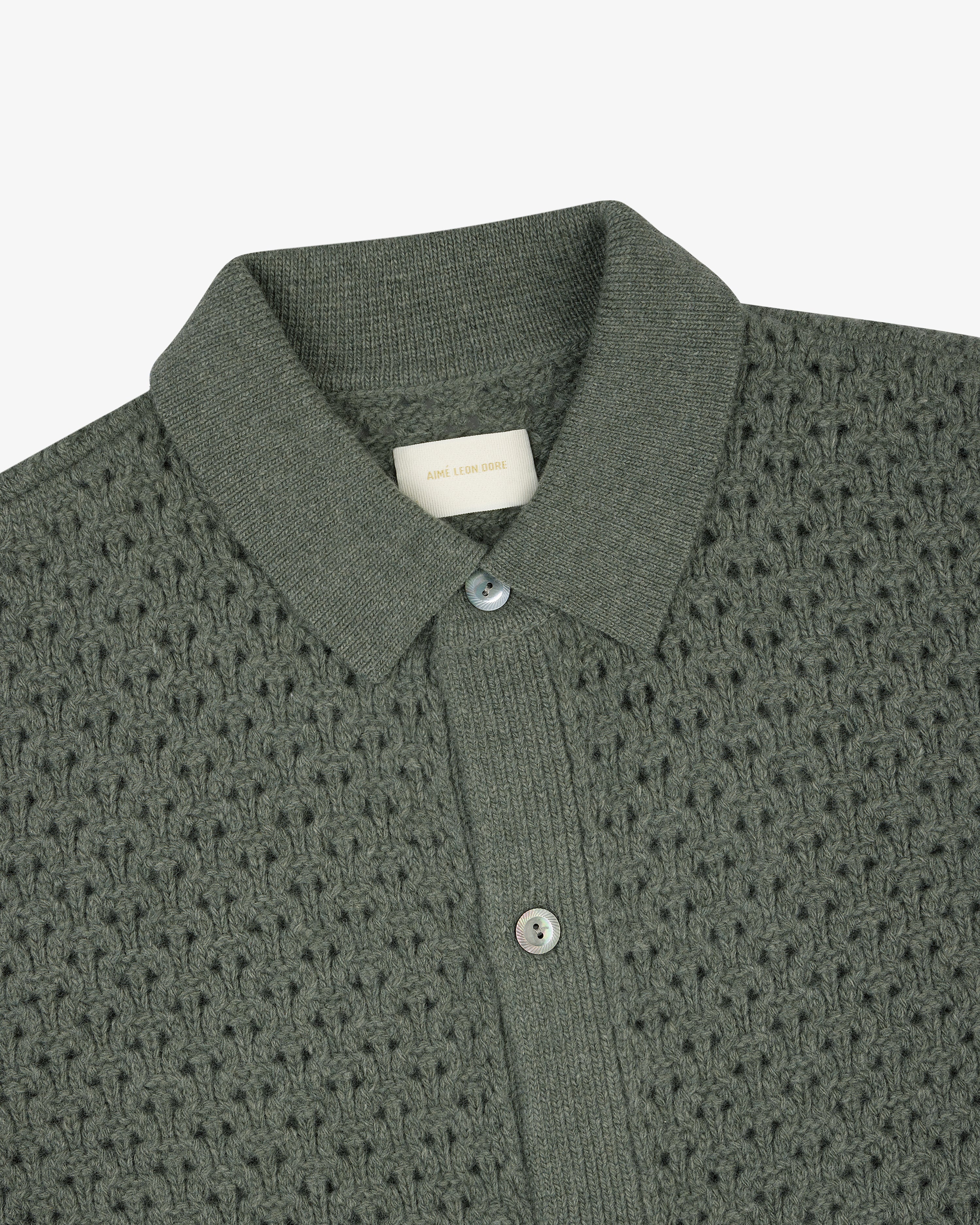 Textured green knit polo cardigan with buttons and an Aime Leon Dore tag at the inside neckline.