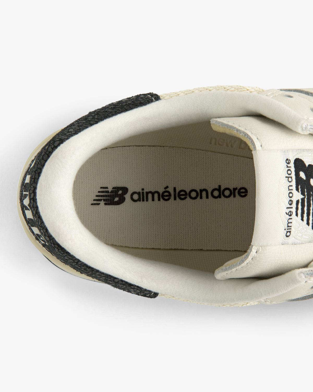 Top view of ALD / New Balance 475 white sneaker with logos on the insole and tongue.