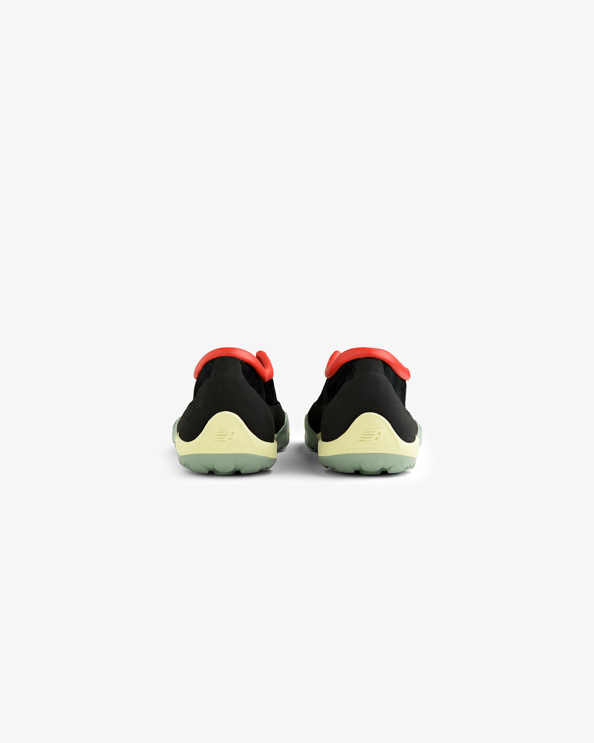 The ALD / New Balance MT10T Sport Shoe features black uppers, yellow-green soles, and red accents, seen from the back.