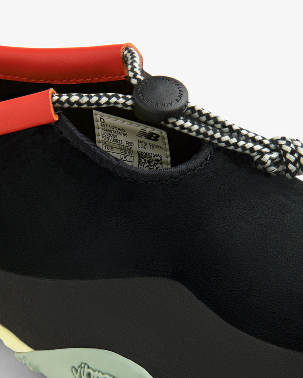 Close-up of the black ALD / New Balance MT10T Sport Shoe with patterned laces, orange trim, and Vibram branding.