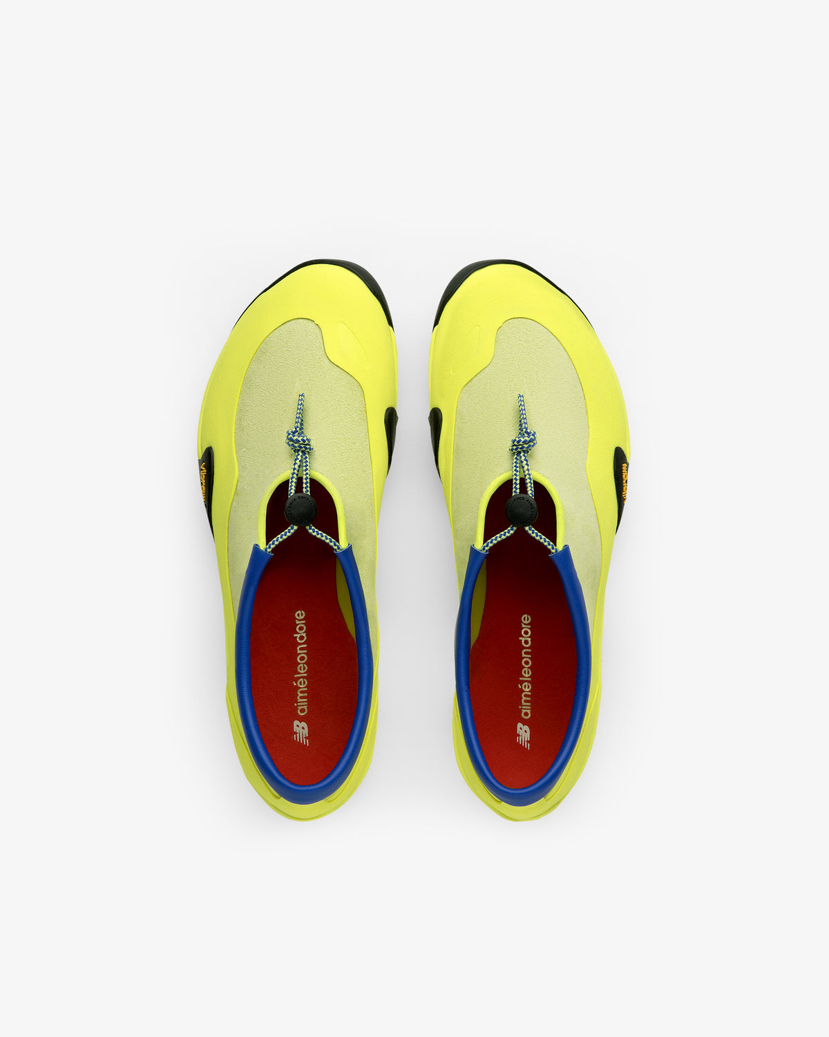 Top view of ALD / New Balance MT10T Sport Shoes—yellow slip-ons with blue trim, red insoles, on white background.
