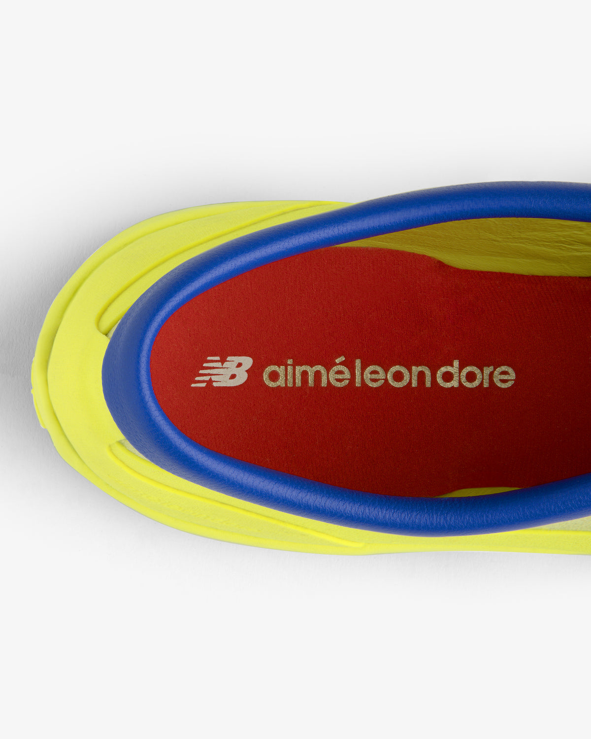 Top view of ALD / New Balance MT10T Sport Shoe with red NB Aimé Leon Dore insole, yellow sole, and blue trim.