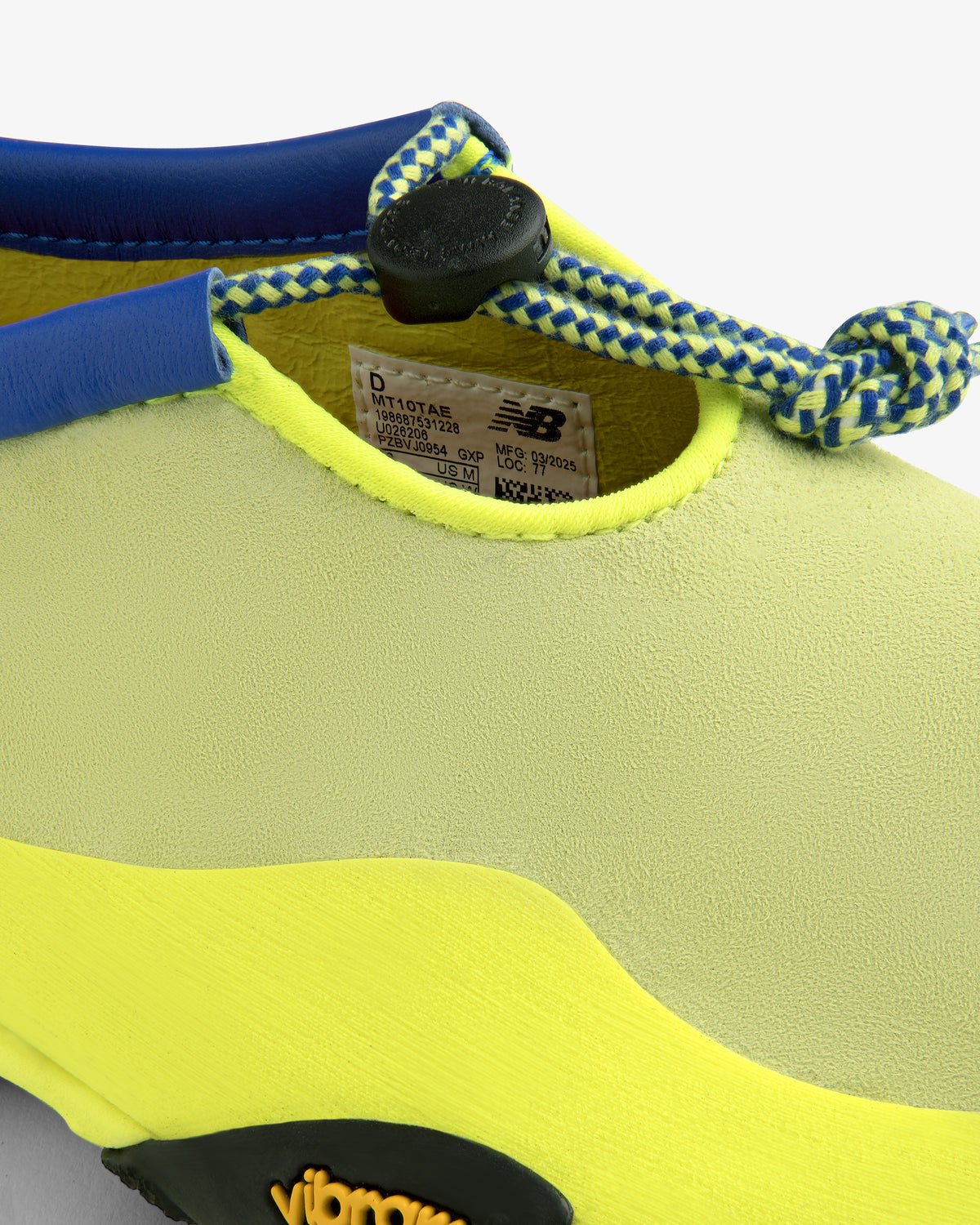 Close-up of ALD / New Balance MT10T Sport Shoe in yellow and blue with toggle lace and visible branding.