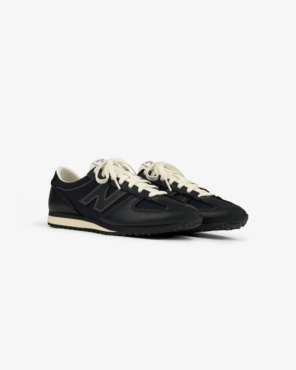 A pair of ALD / New Balance 471 sneakers in black with white laces and beige soles on a plain white background.