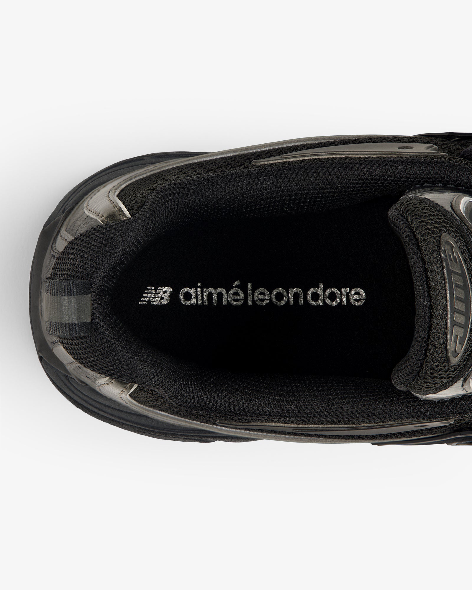 Top view of a black ALD / New Balance RC56 sneaker with "aimé leon dore" printed in white on the insole.