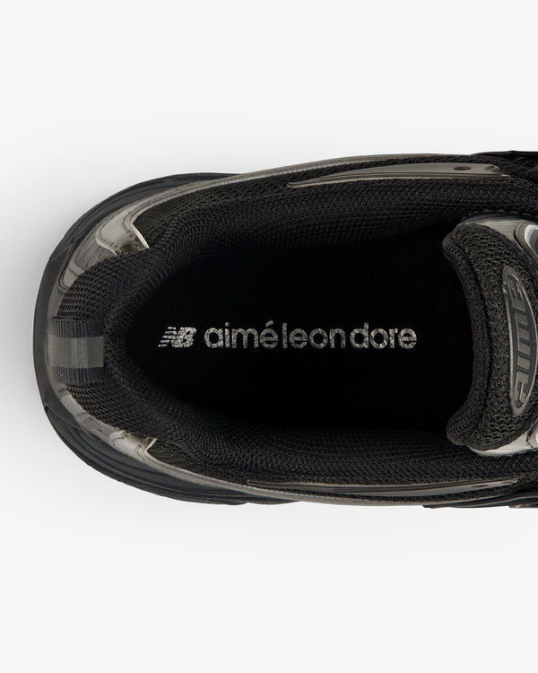 Top view of a black ALD / New Balance RC56 sneaker with "aimé leon dore" printed in white on the insole.