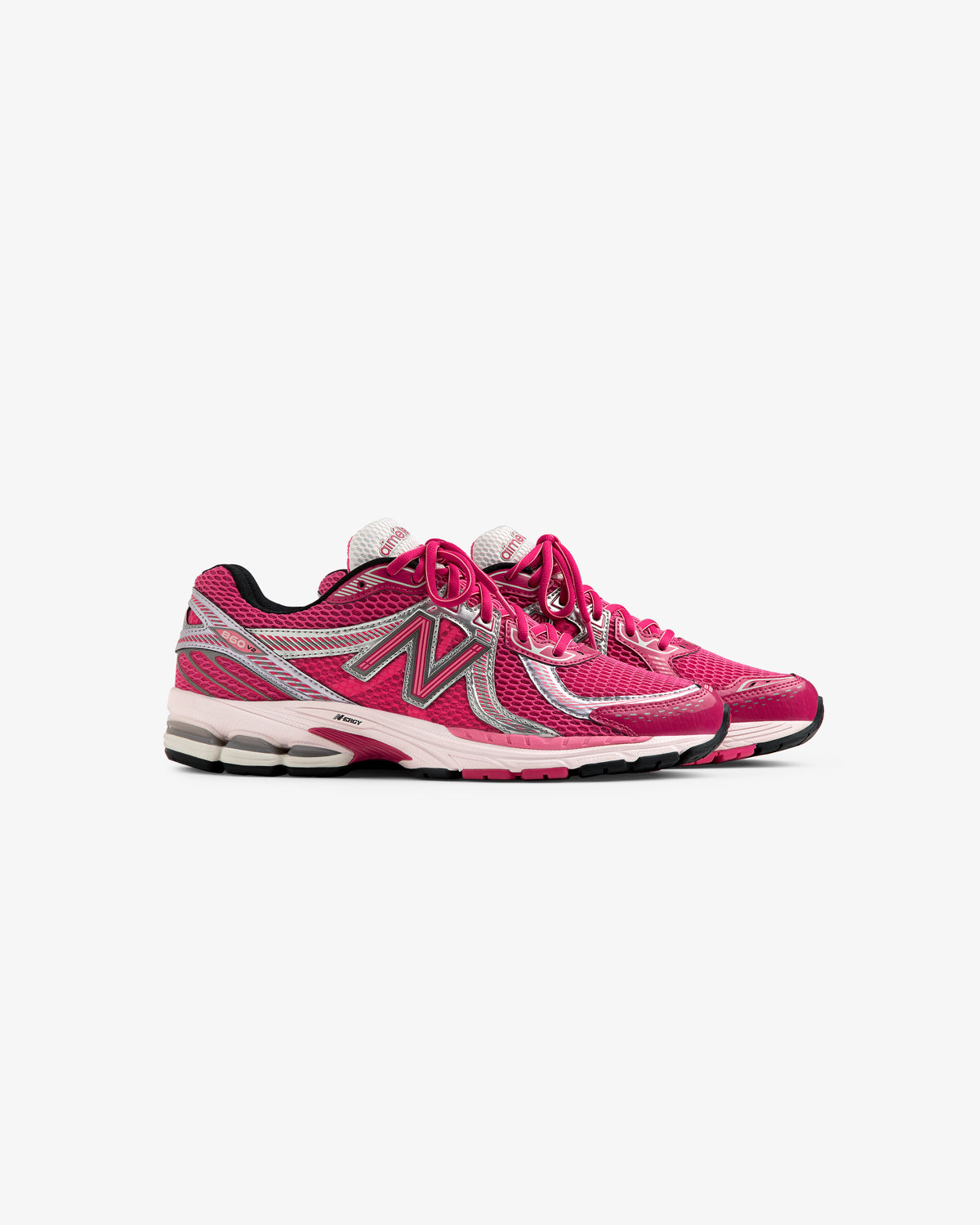 Side view of ALD / New Balance 860v2 running shoes in pink and white with silver accents, on a white background.