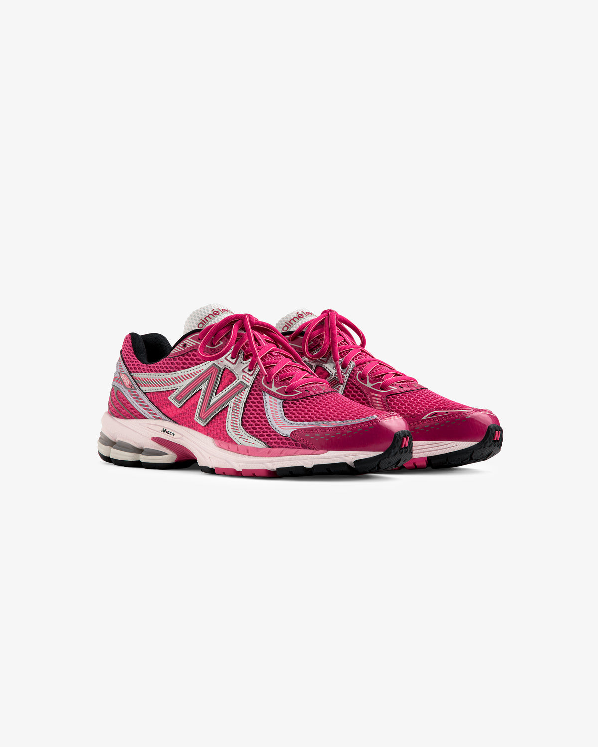 A pair of ALD / New Balance 860v2 pink and gray running shoes with white laces on a plain white background.