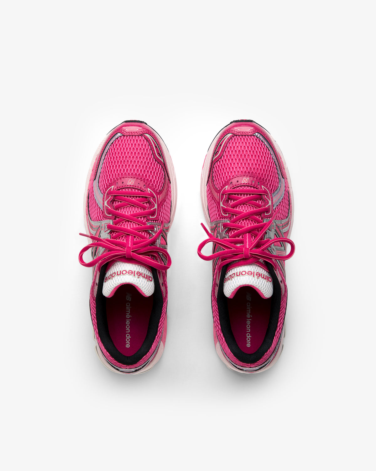 ALD / New Balance 860v2 pink running shoes with laces, top view on a white background.