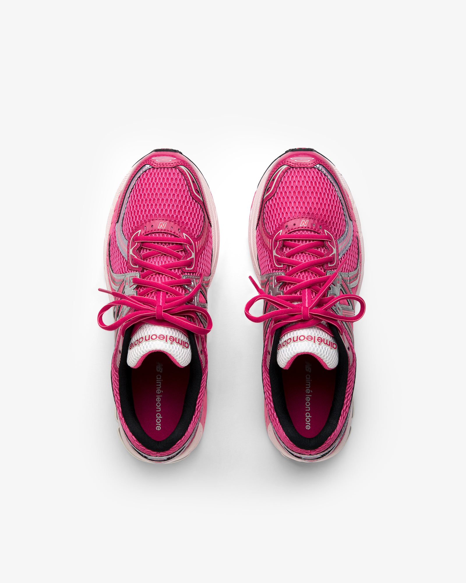 ALD / New Balance 860v2 pink running shoes with laces, top view on a white background.
