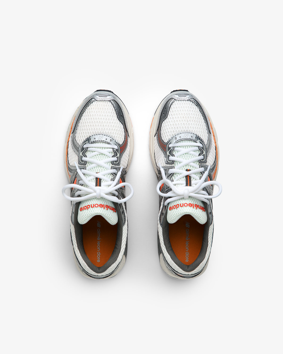 ALD / New Balance 860v2 white mesh sneakers with gray and orange accents, top view on a white background.