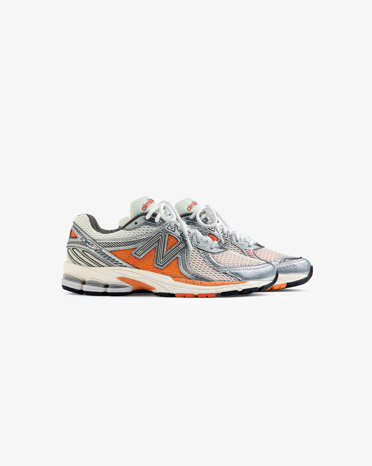 ALD / New Balance 860v2 running shoes with gray mesh, orange & black accents, white laces, and black soles.