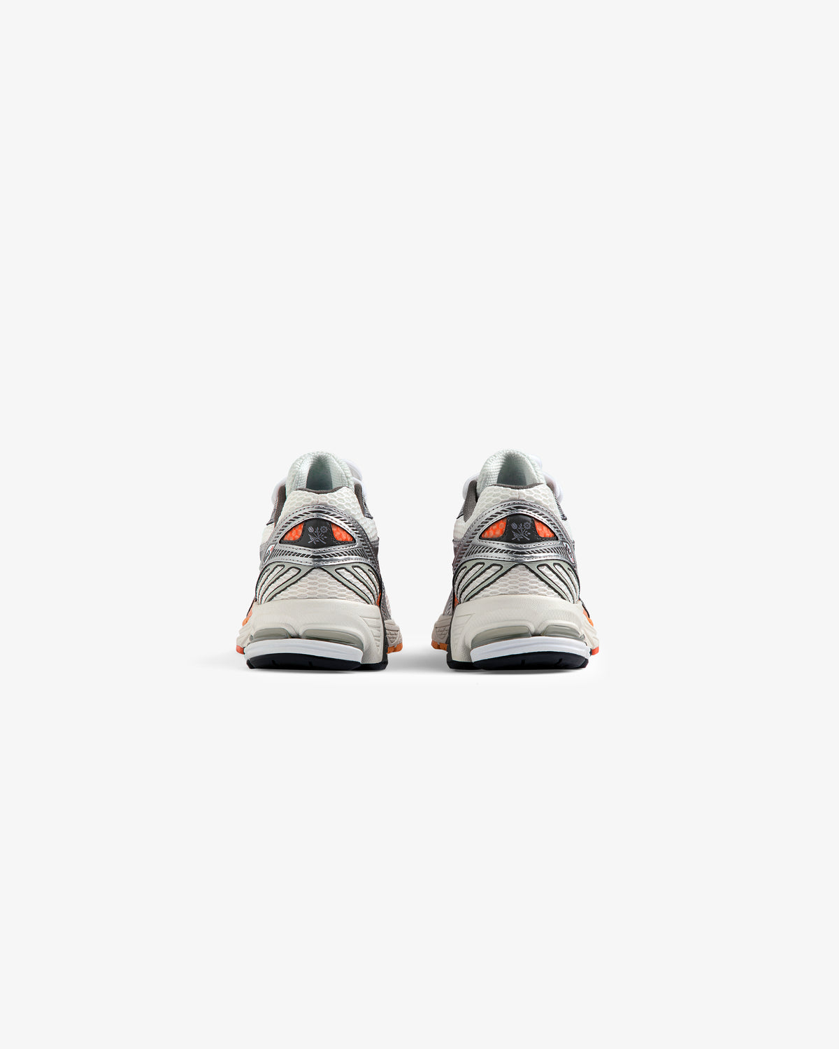 A pair of ALD / New Balance 860v2 gray and orange sneakers shown from the back on a white background.